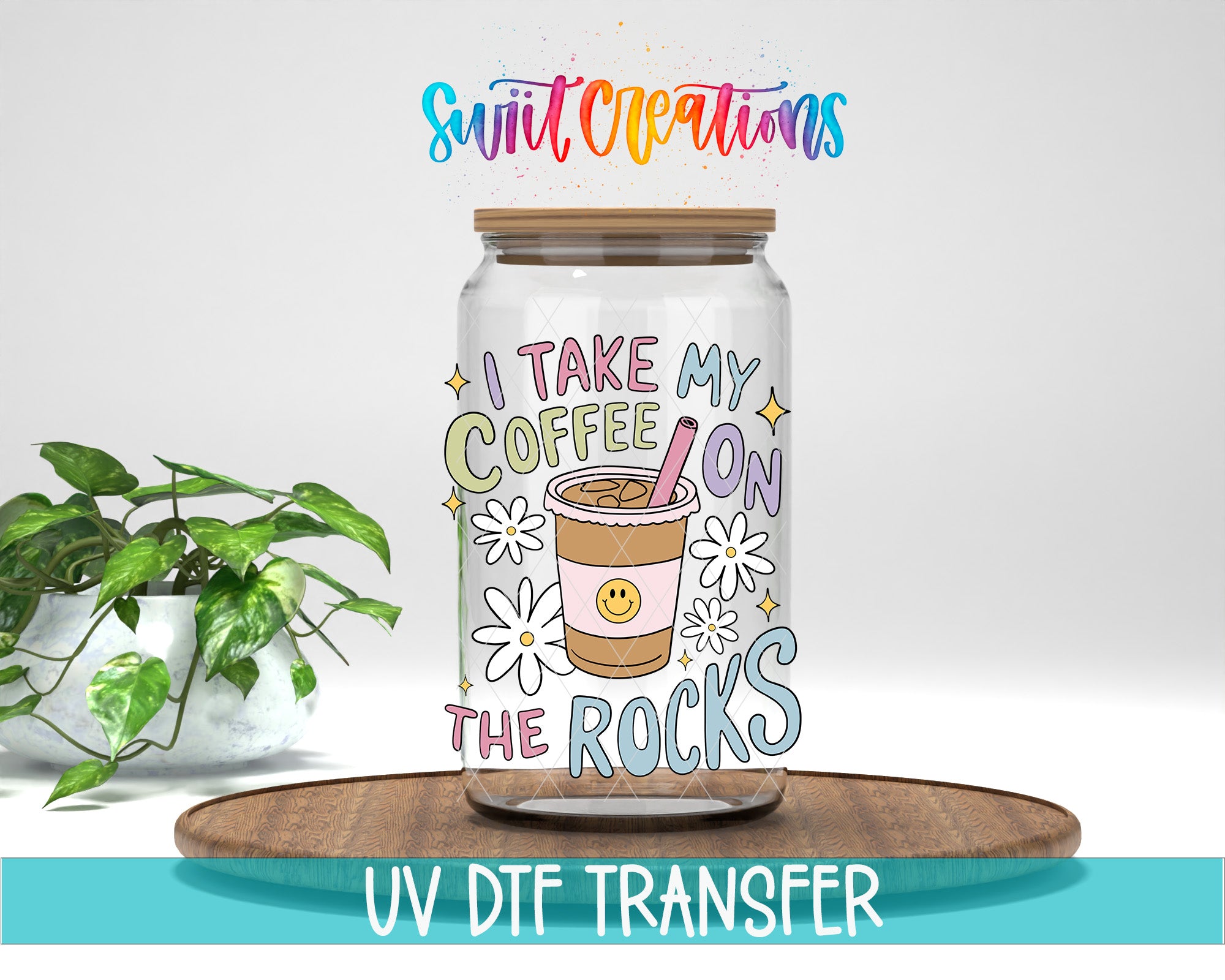 A glass jar with a colorful design and text, placed on a wooden surface next to a potted plant.