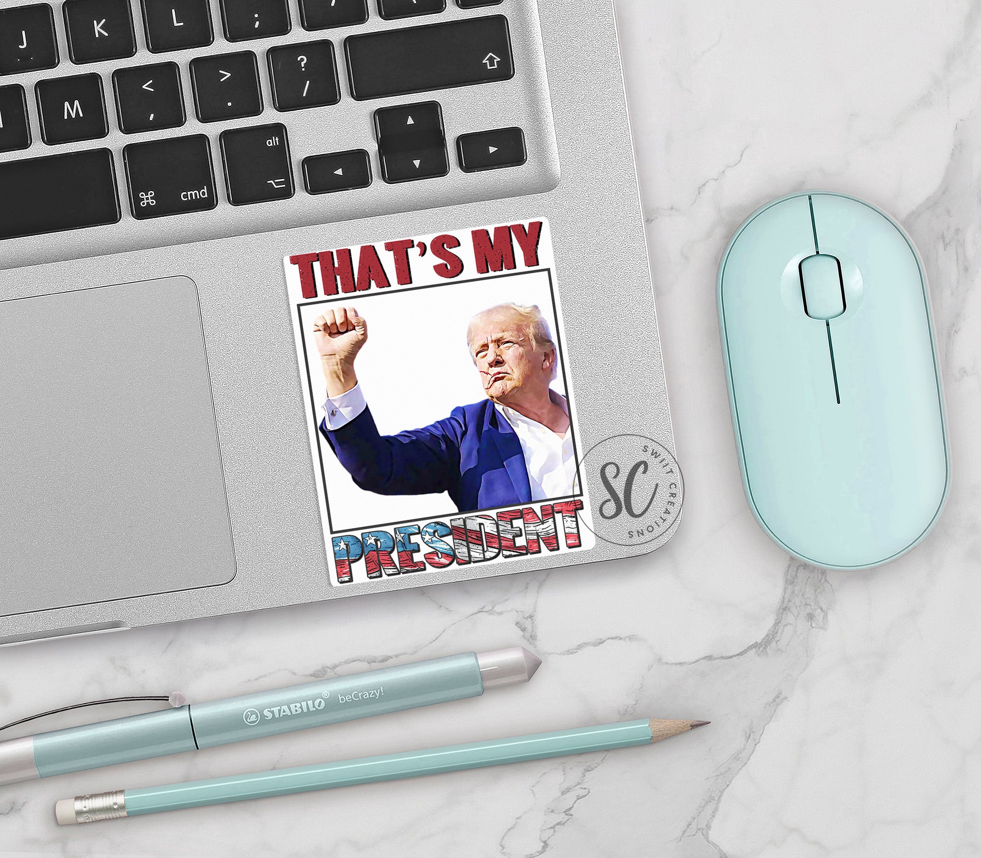a mouse, keyboard, and sticker with a picture of bill clinton on it