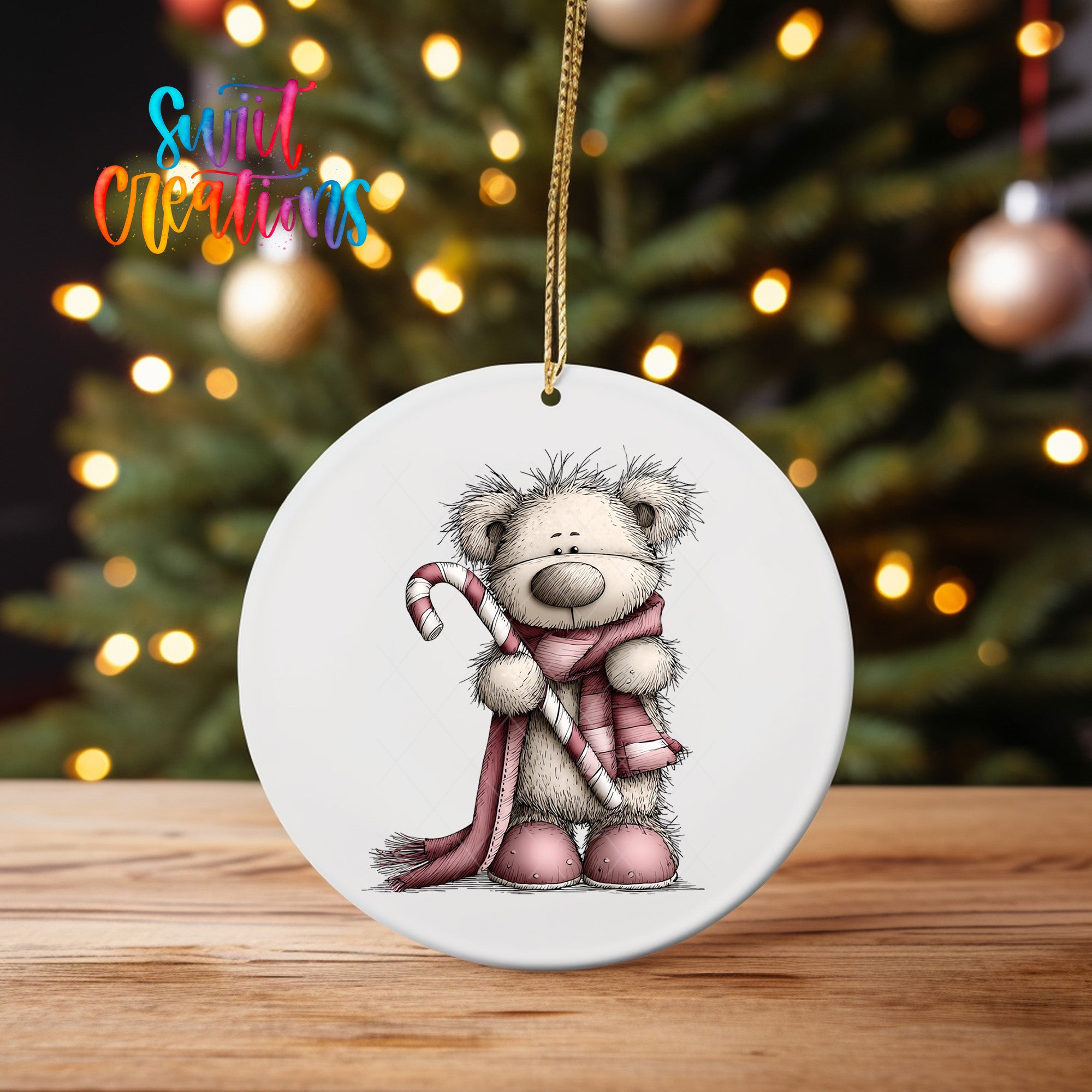 A white ceramic ornament featuring a teddy bear holding a candy cane, with a blurred background of a Christmas tree and colorful lights.