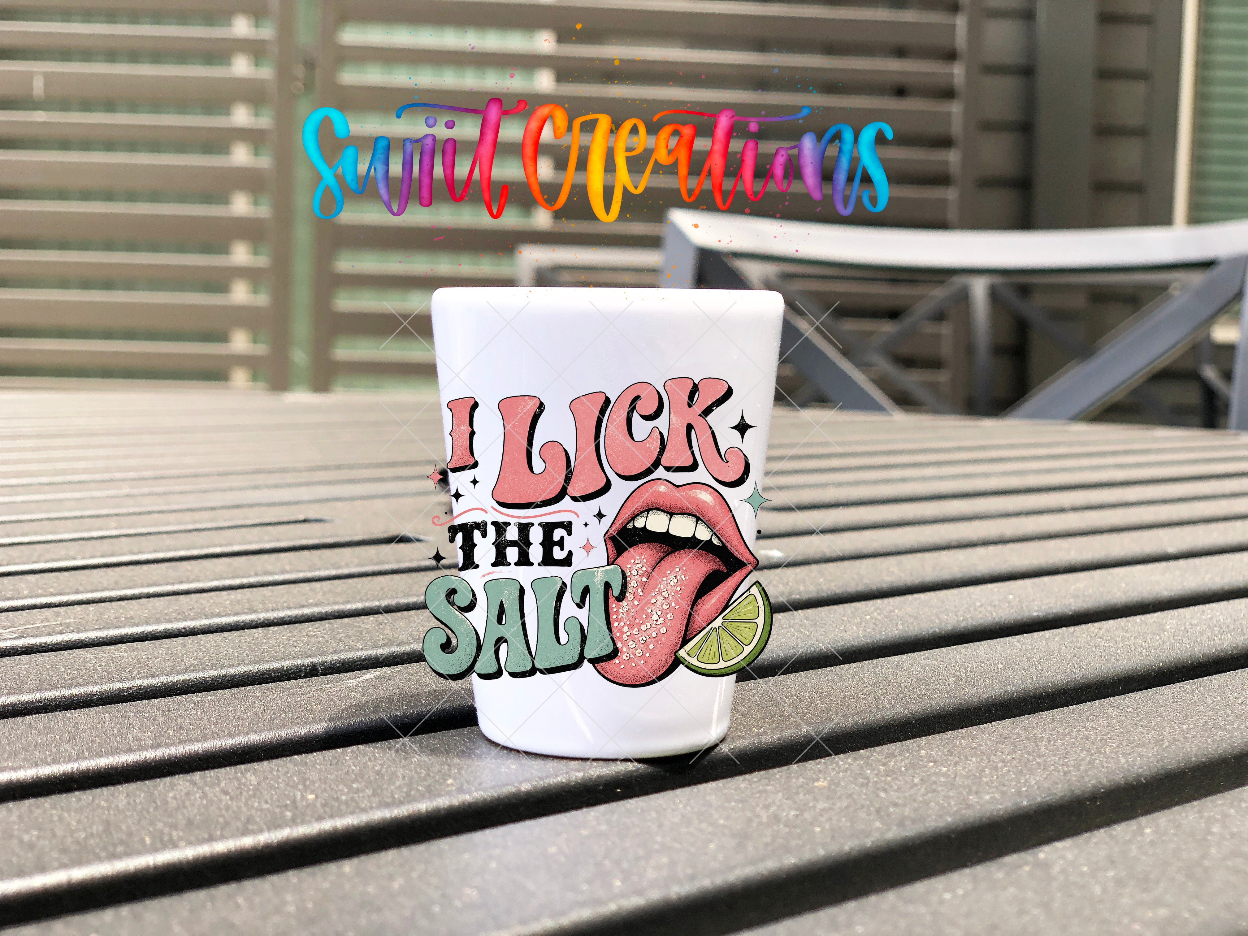 A white mug with a colorful graphic design and text on it, placed on a wooden surface.
