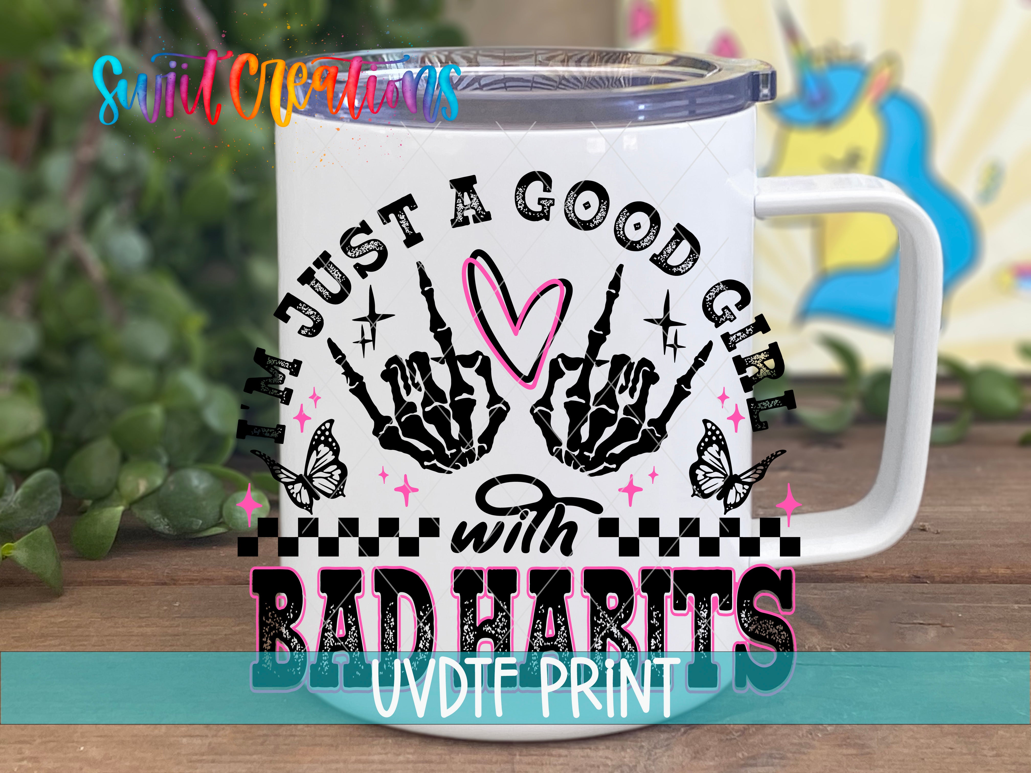 A white mug with a colorful graphic design featuring a skeleton hand and the text "I'm just a good girl with bad habits" printed on it.