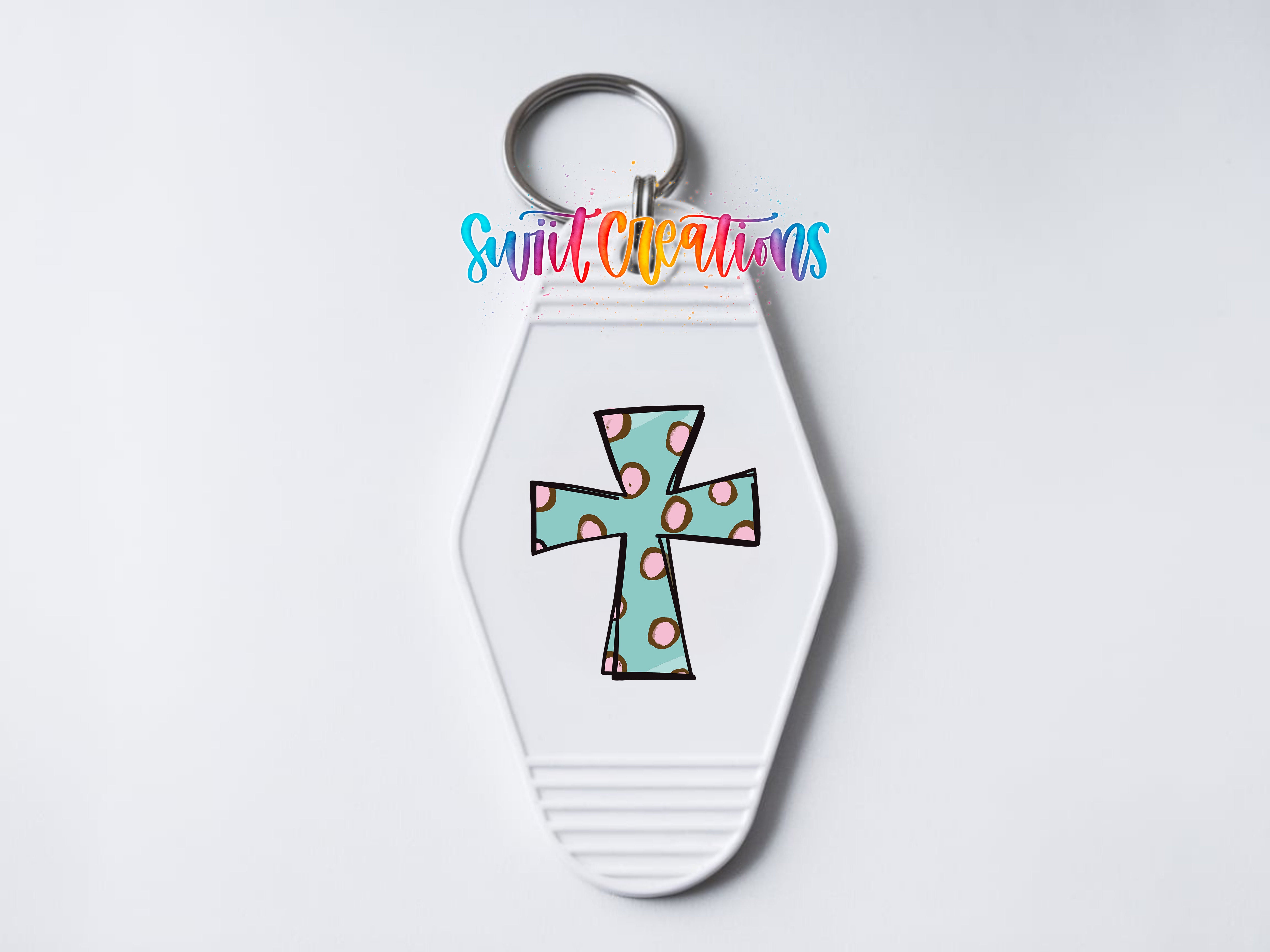 A white keychain with a colorful cross design on it.