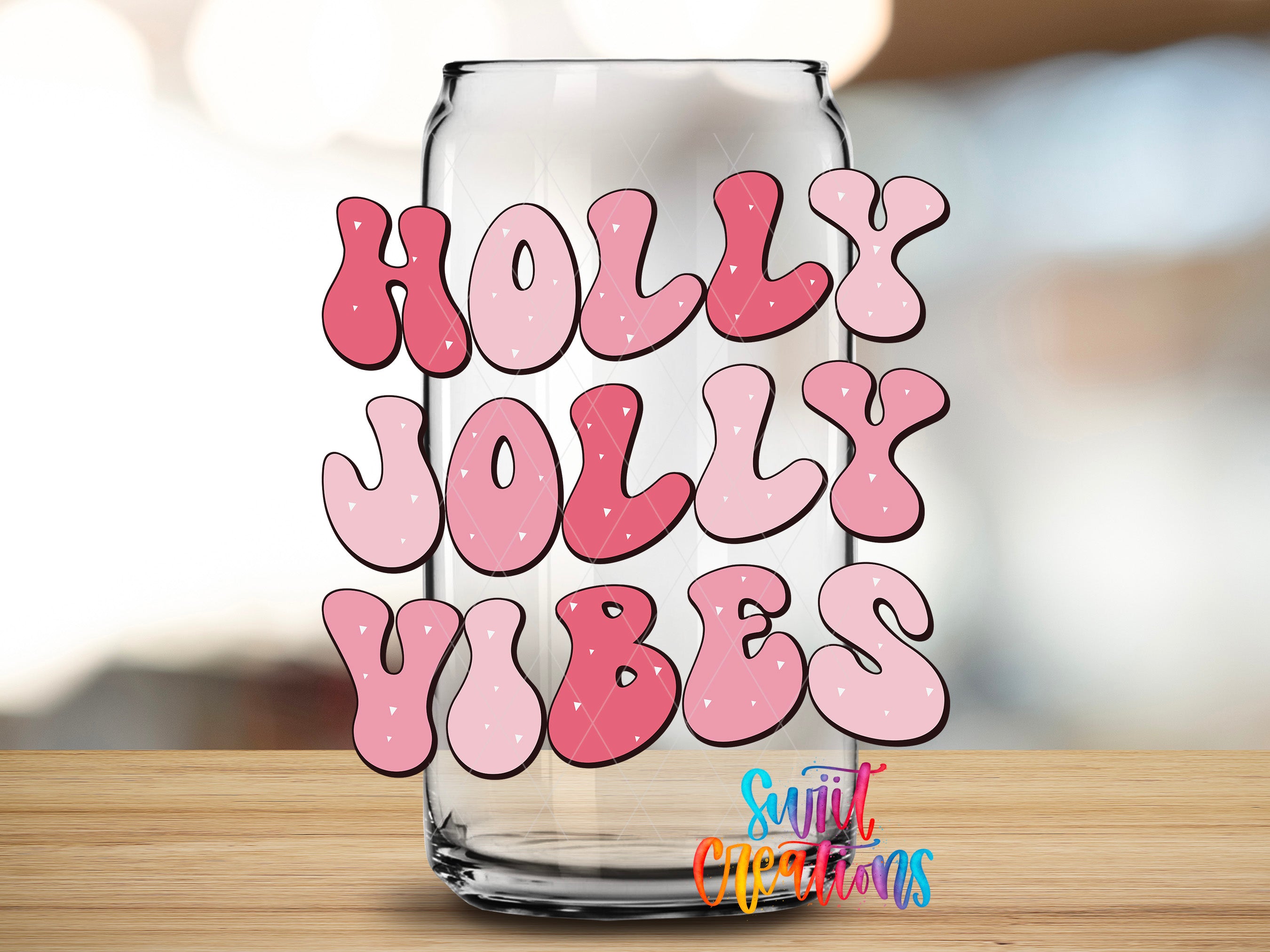 A glass can with the text "HOLY JOLY VIBES" written on it, along with a watermark that says "Suitcase Creations".