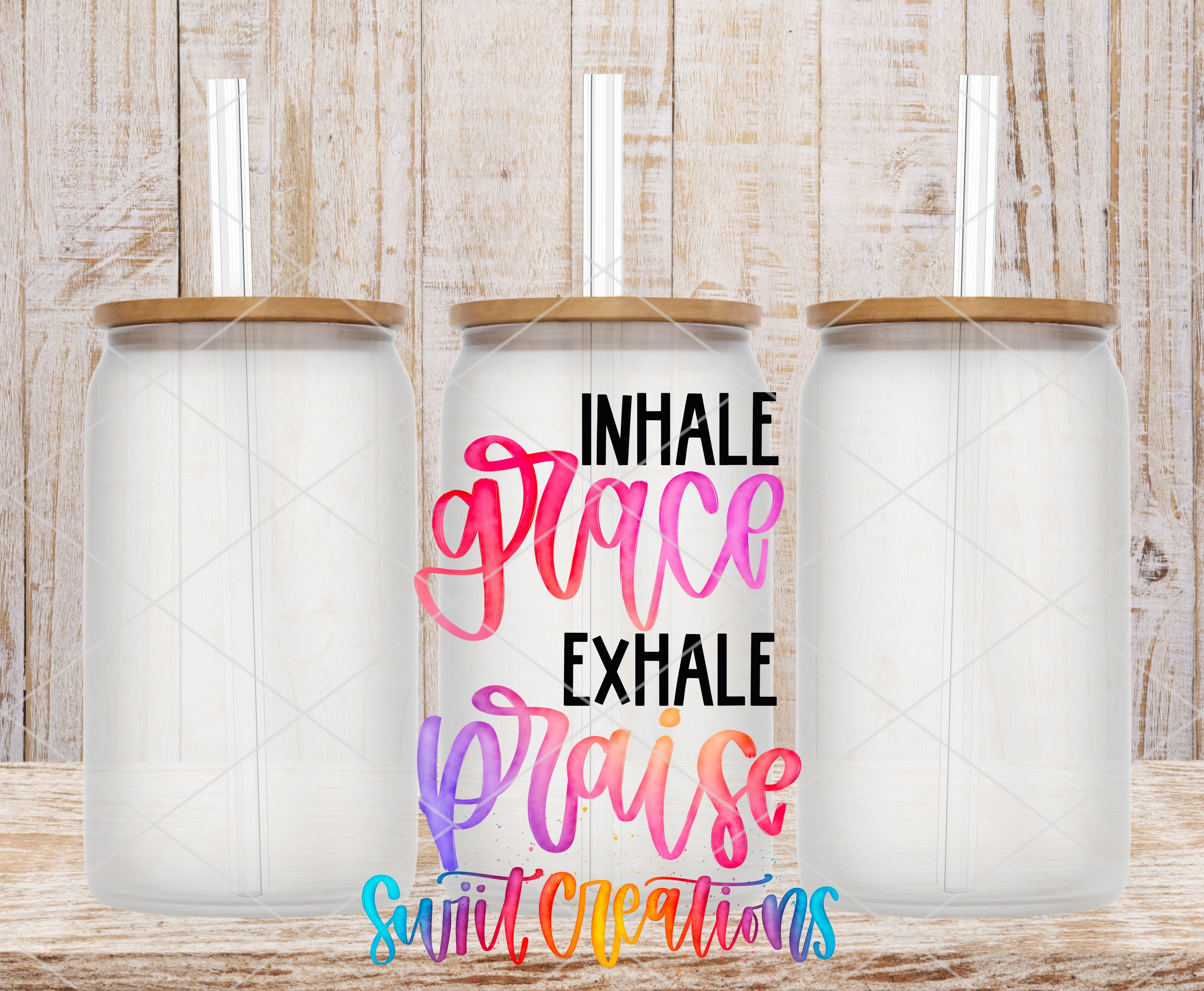 three clear glass jars with wooden lids, arranged in a row against a wooden background. The jars have straws attached to their lids. The text in the image is a colorful and artistic design that reads "INHALE GRACE EXHAISE PRAISE SUITCCREATIONS".