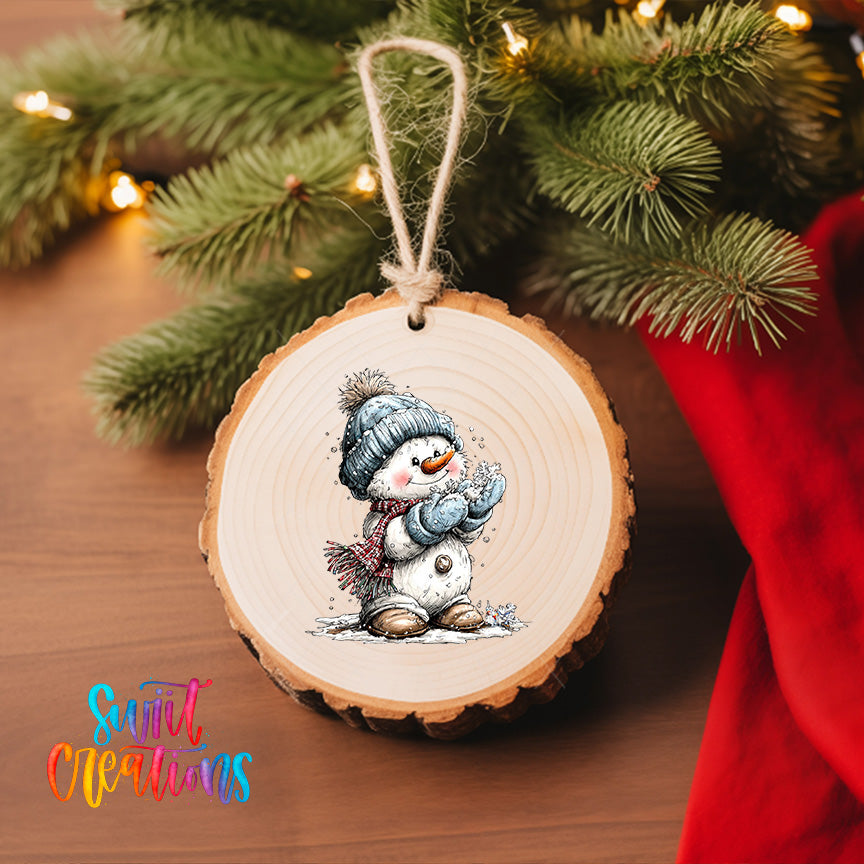 A wooden ornament featuring a snowman is hanging on a Christmas tree, surrounded by pine branches and twinkling lights.