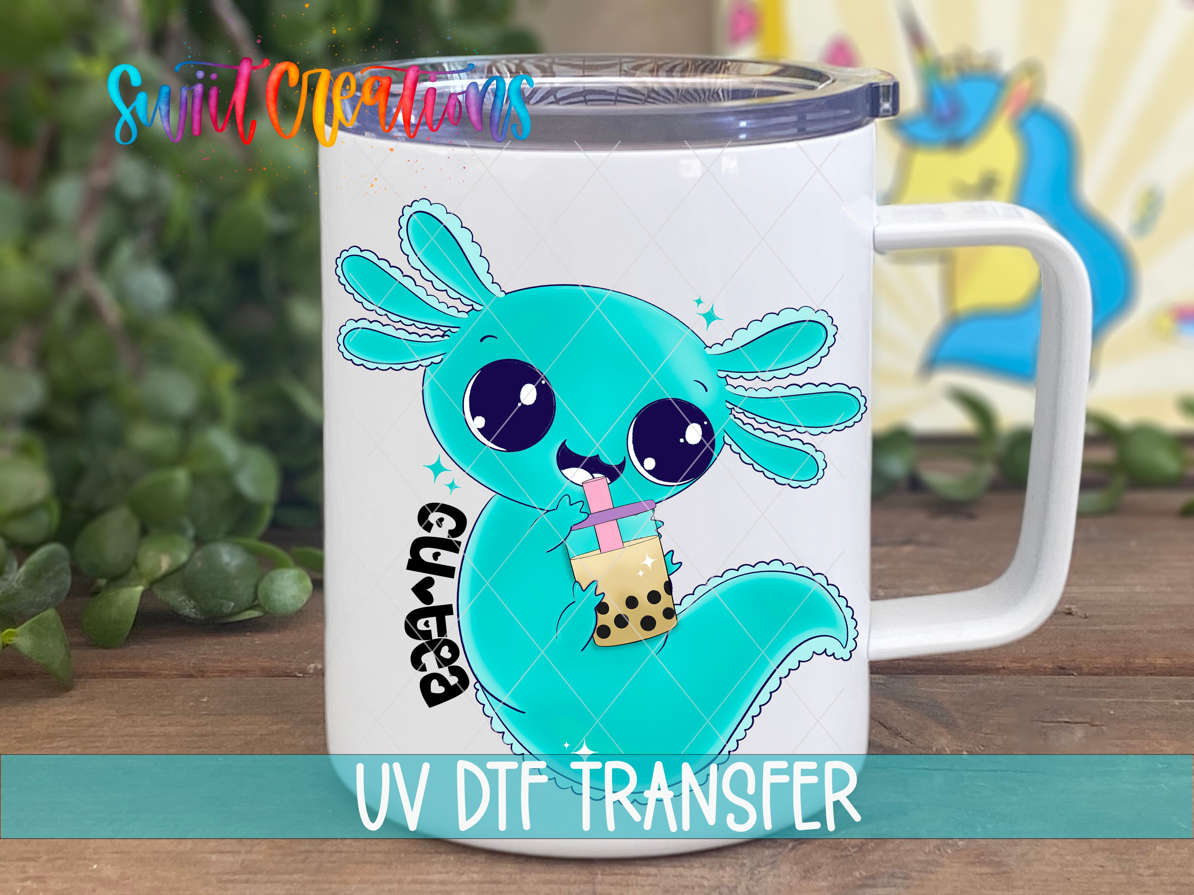 A white mug with a cartoon image of a blue axolotl holding a bubble tea drink, along with the text "UV Dtf Transfer".