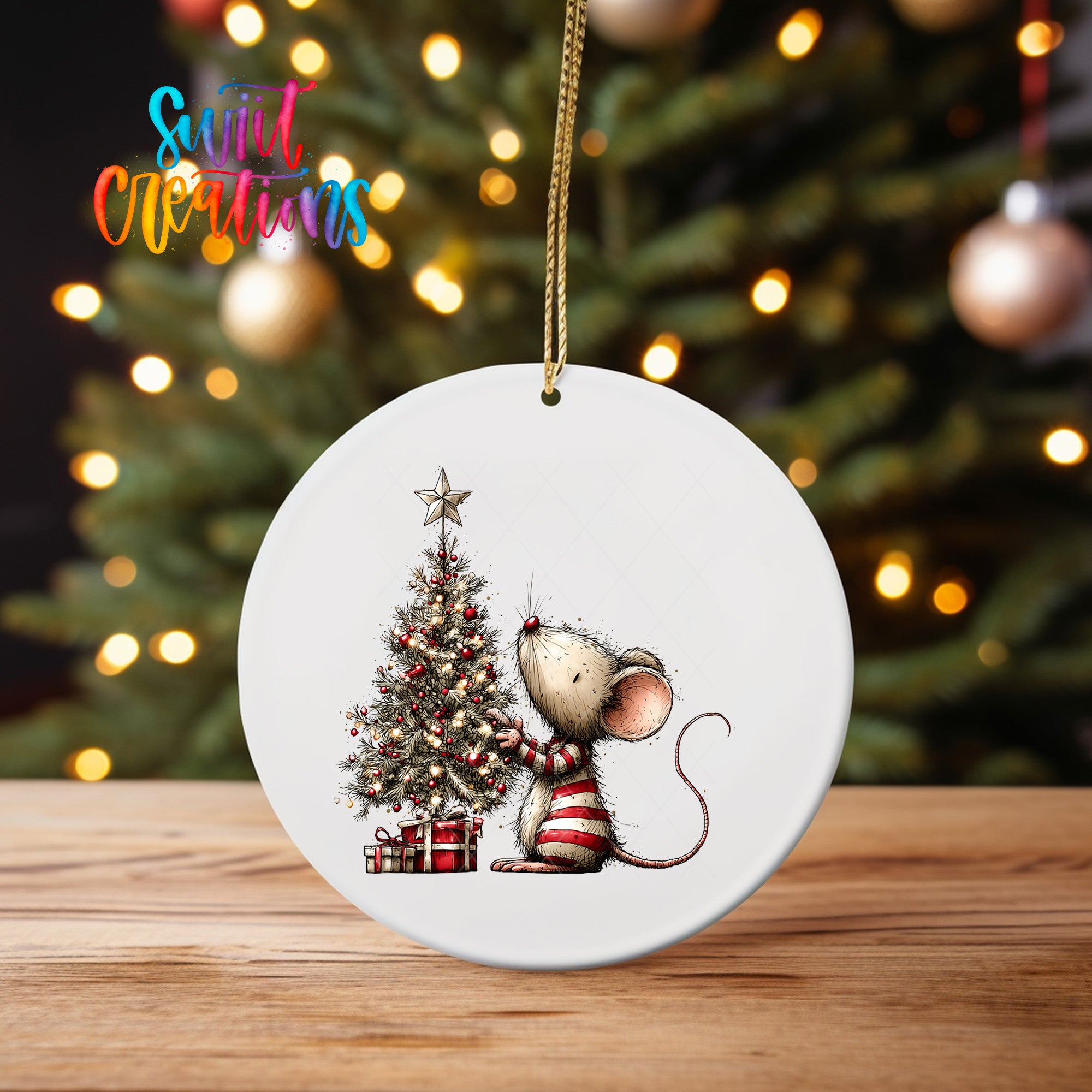 A white ceramic ornament featuring a cartoon mouse sitting next to a Christmas tree, with presents underneath.