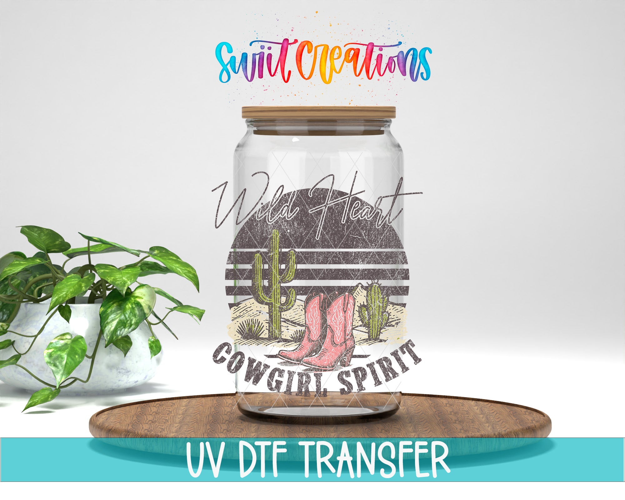 a glass jar with a cowboy-themed design, including a cactus and boots, placed on a wooden surface. The jar has a label that says "Wild Heart Cowgirl Spirit".