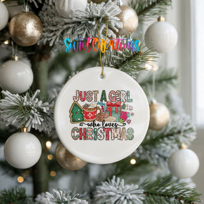 A white Christmas ornament with a colorful design hangs from a tree, surrounded by other ornaments.