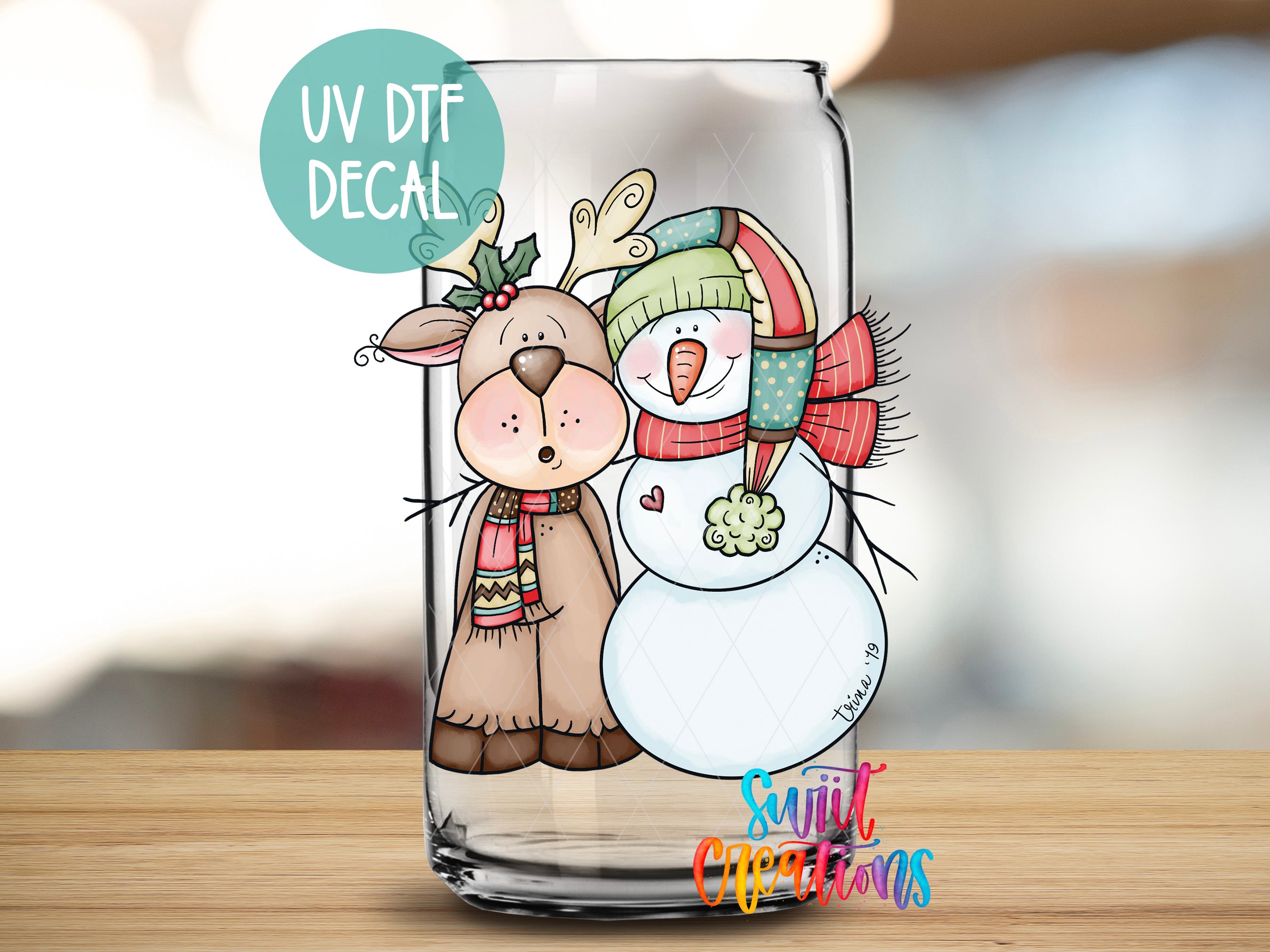a glass with a picture of a snowman and a reindeer