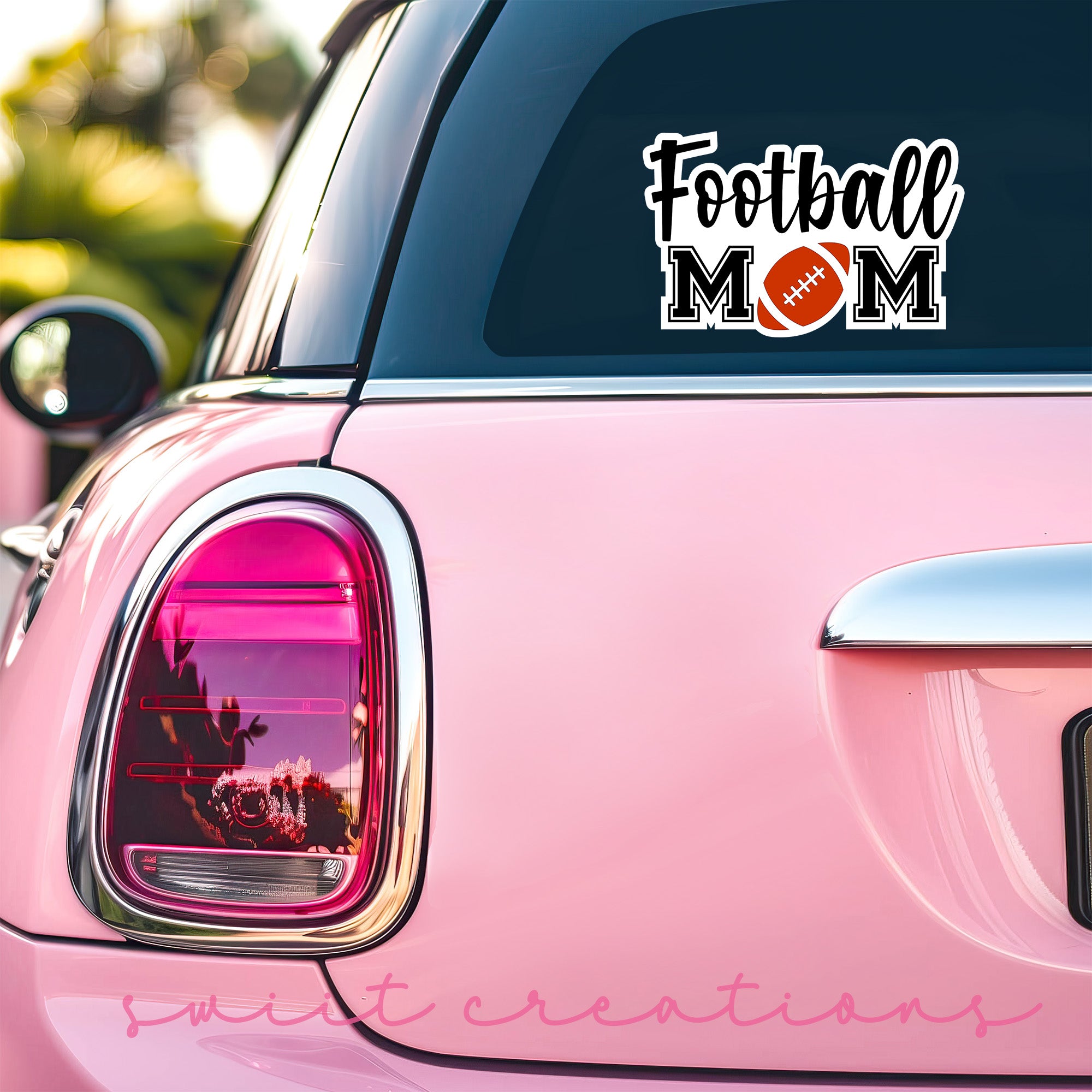 a pink car with a football mom decal on it