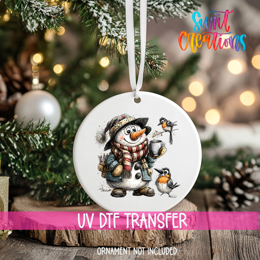 A white ceramic ornament featuring a snowman and two birds, hanging on a Christmas tree.