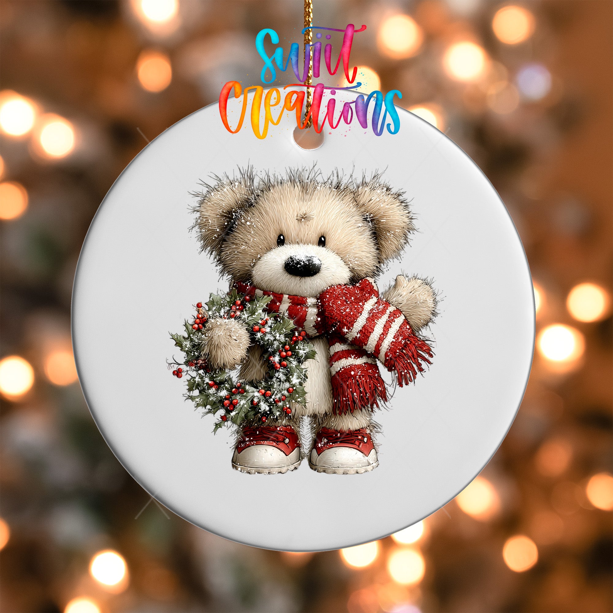 A white ornament featuring a teddy bear wearing a red and white striped scarf and red shoes, holding a wreath.
