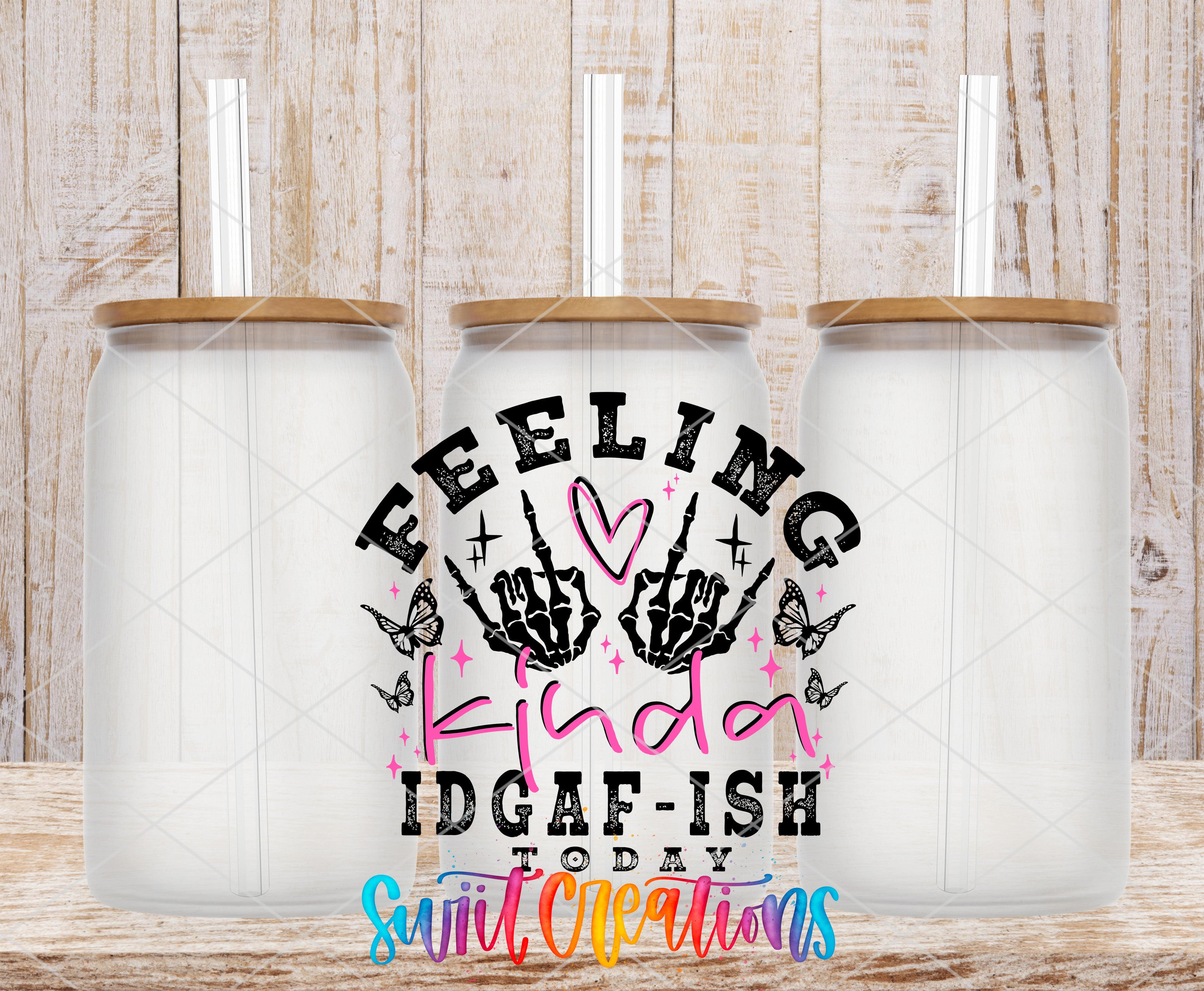 three clear glass jars with lids, arranged in a row against a wooden background. The jars have straws attached to their lids. The image also contains text that reads "Feeling kinda idgafish today" and "Swift Creations", which appears to be a slogan or message related to the jars and straws.