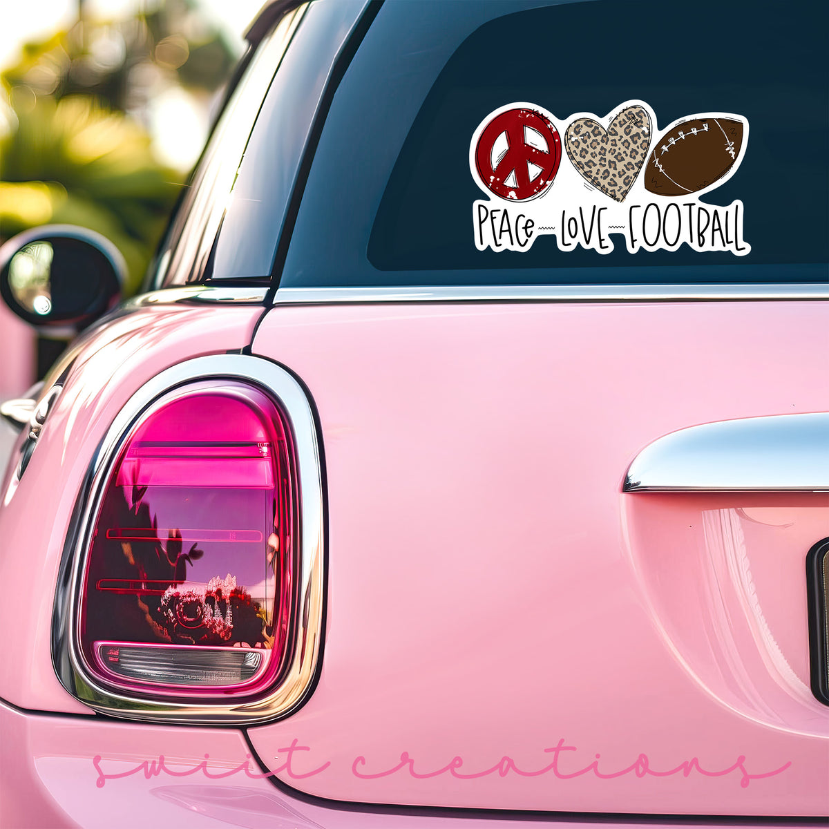 a pink car with a peace love football decal on it