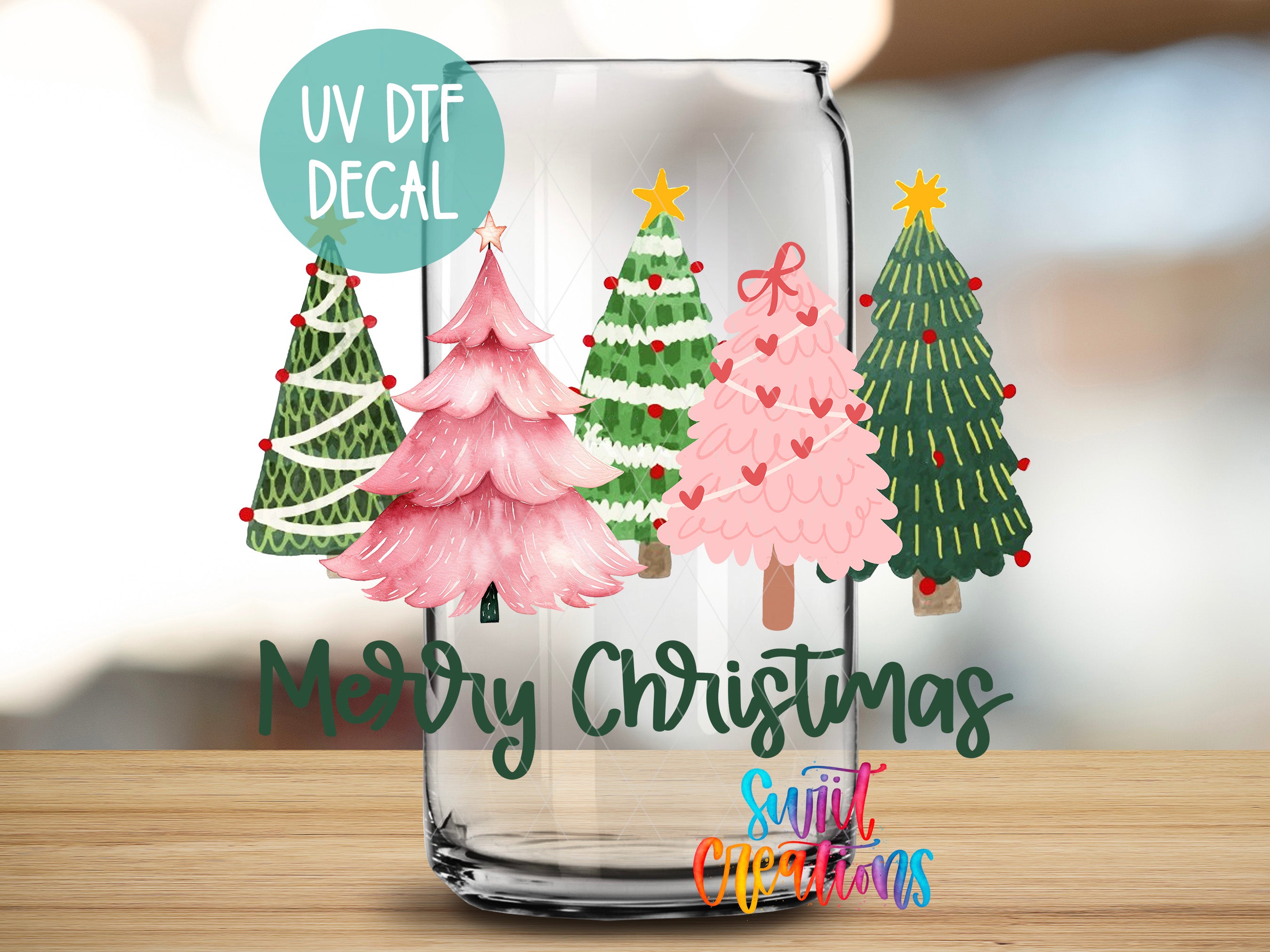 a glass with christmas trees on it sitting on a table