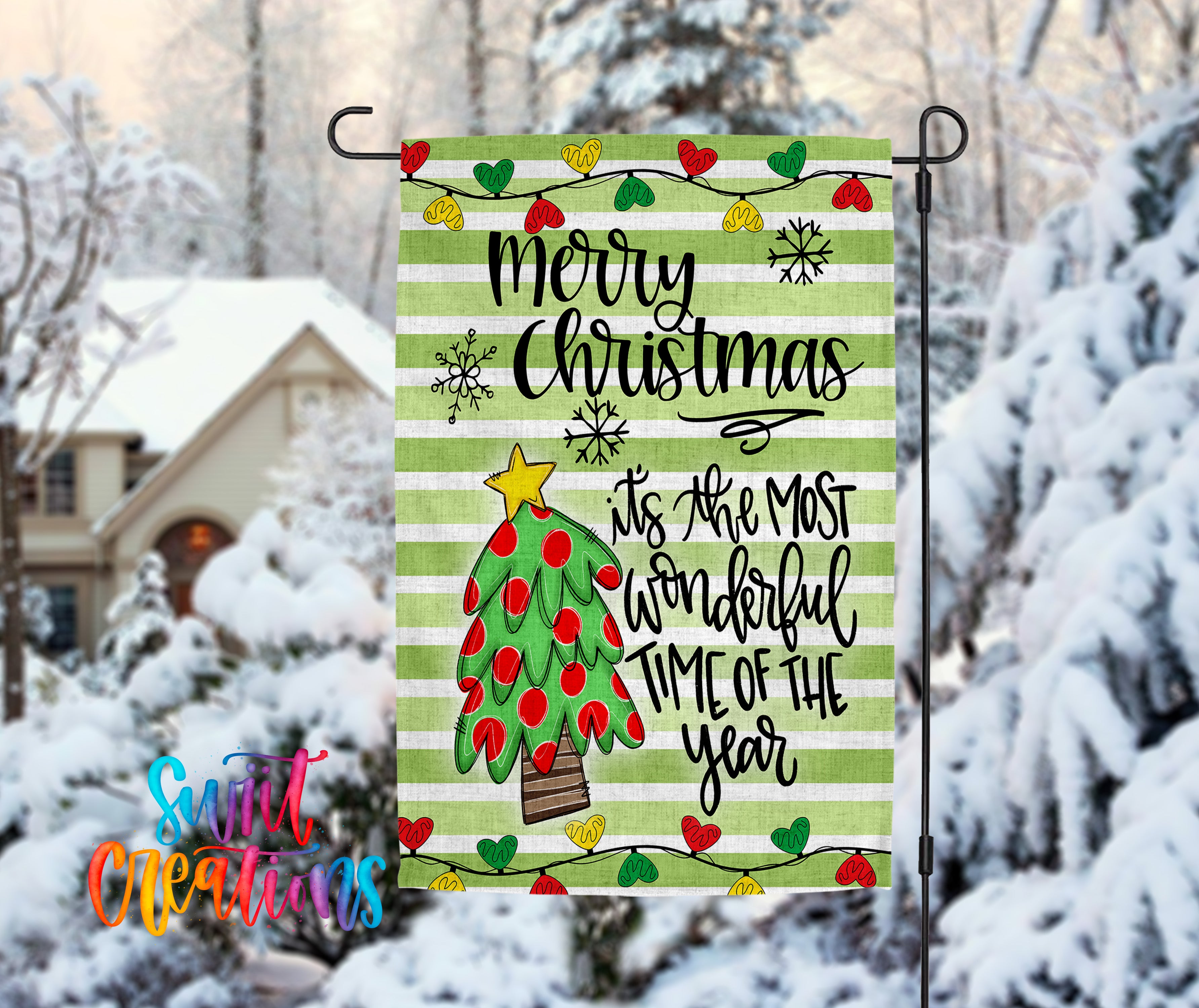 A festive Christmas-themed flag is displayed in a snowy outdoor setting, featuring a tree with red and green ornaments and a star on top.