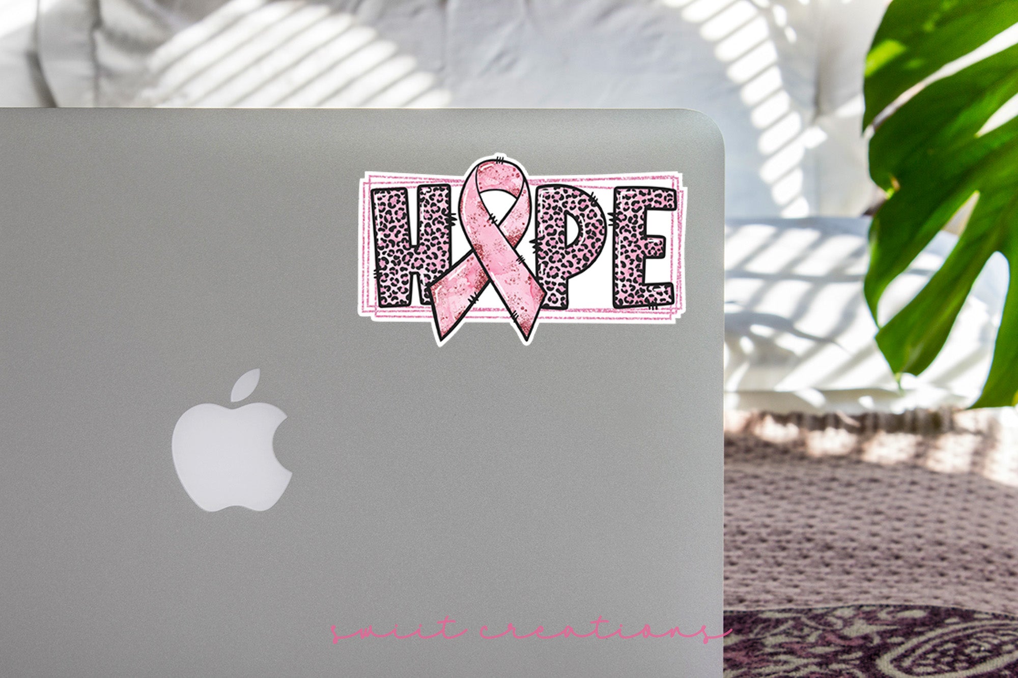 a laptop with a pink ribbon on it