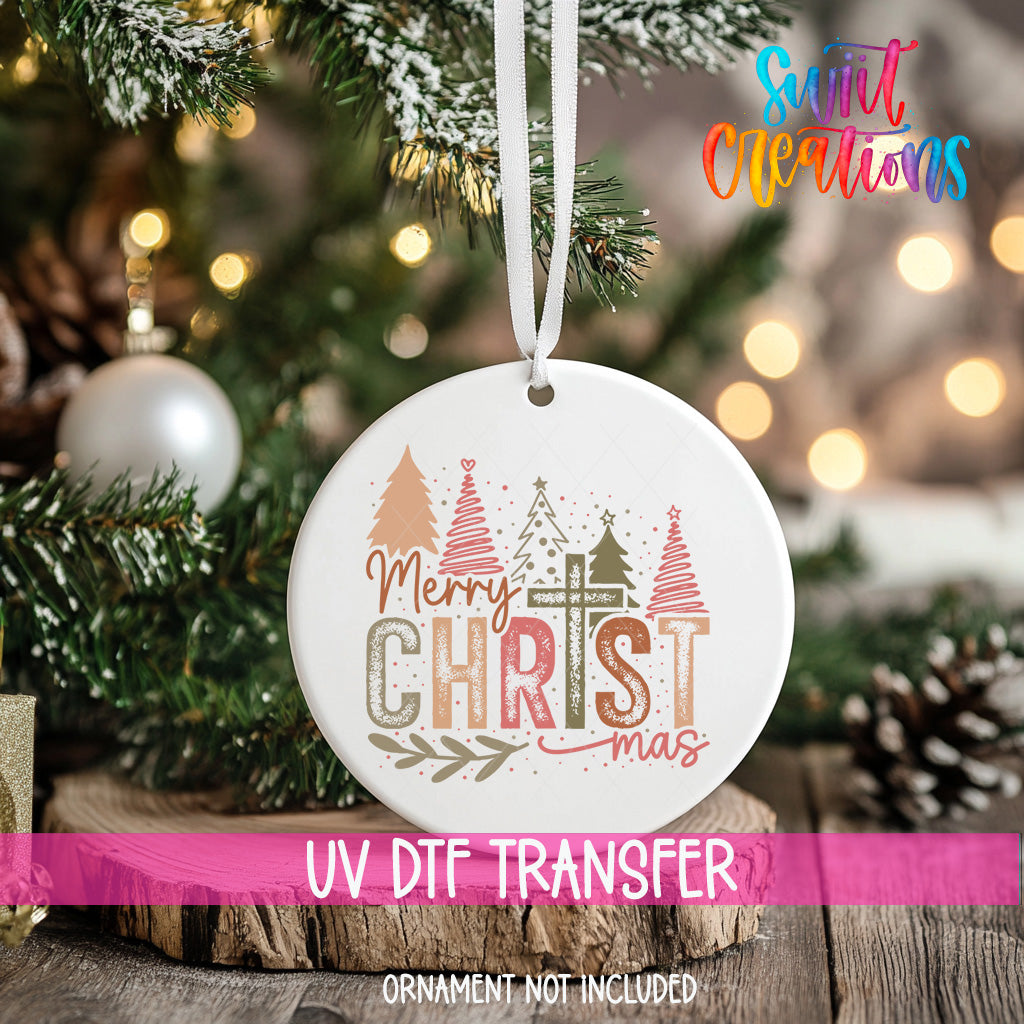 A white Christmas ornament with the text "Merry Christmas" and "Christmas" printed on it, hanging on a decorated Christmas tree.
