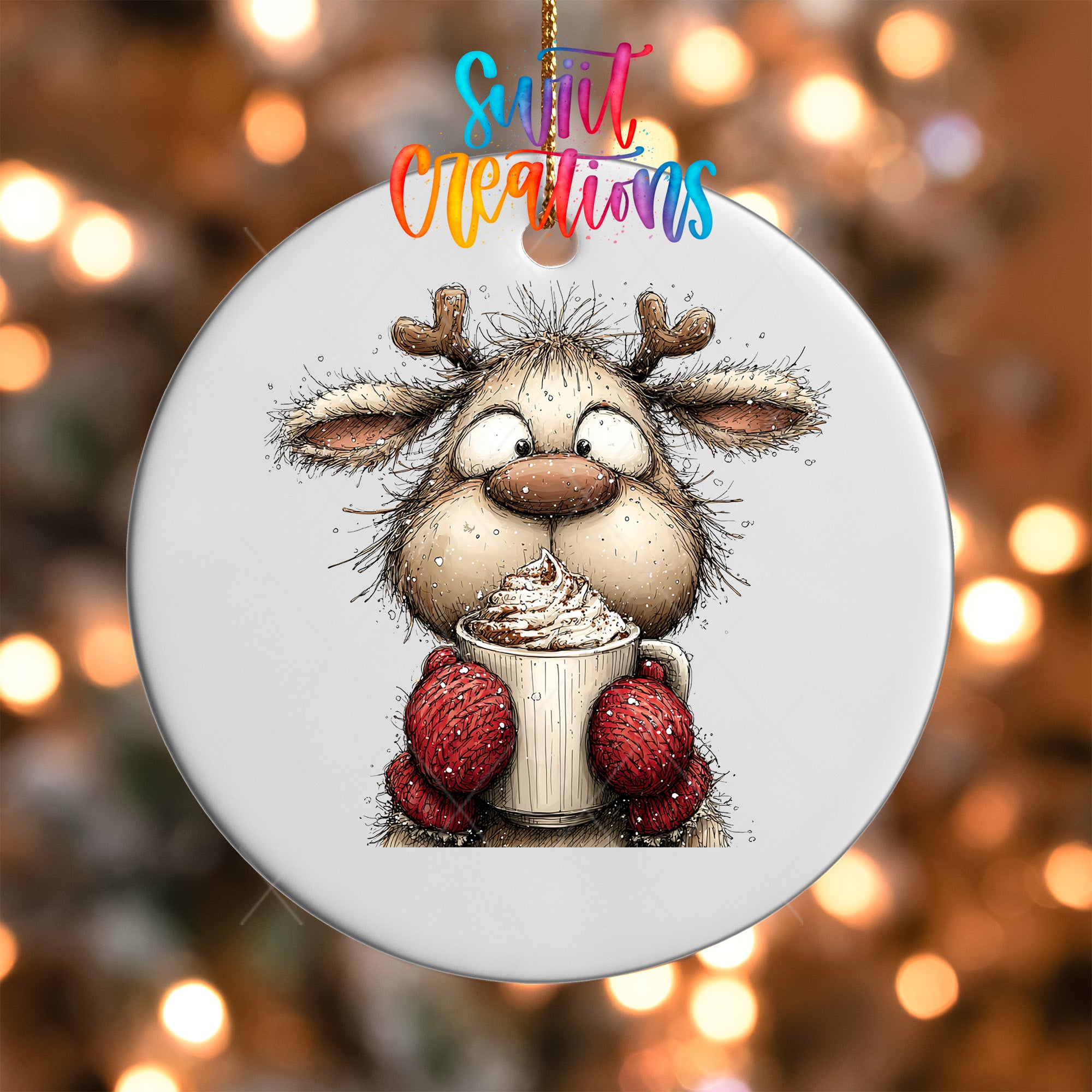 A white ornament with a cartoon reindeer holding a cup of hot chocolate and wearing red mittens.
