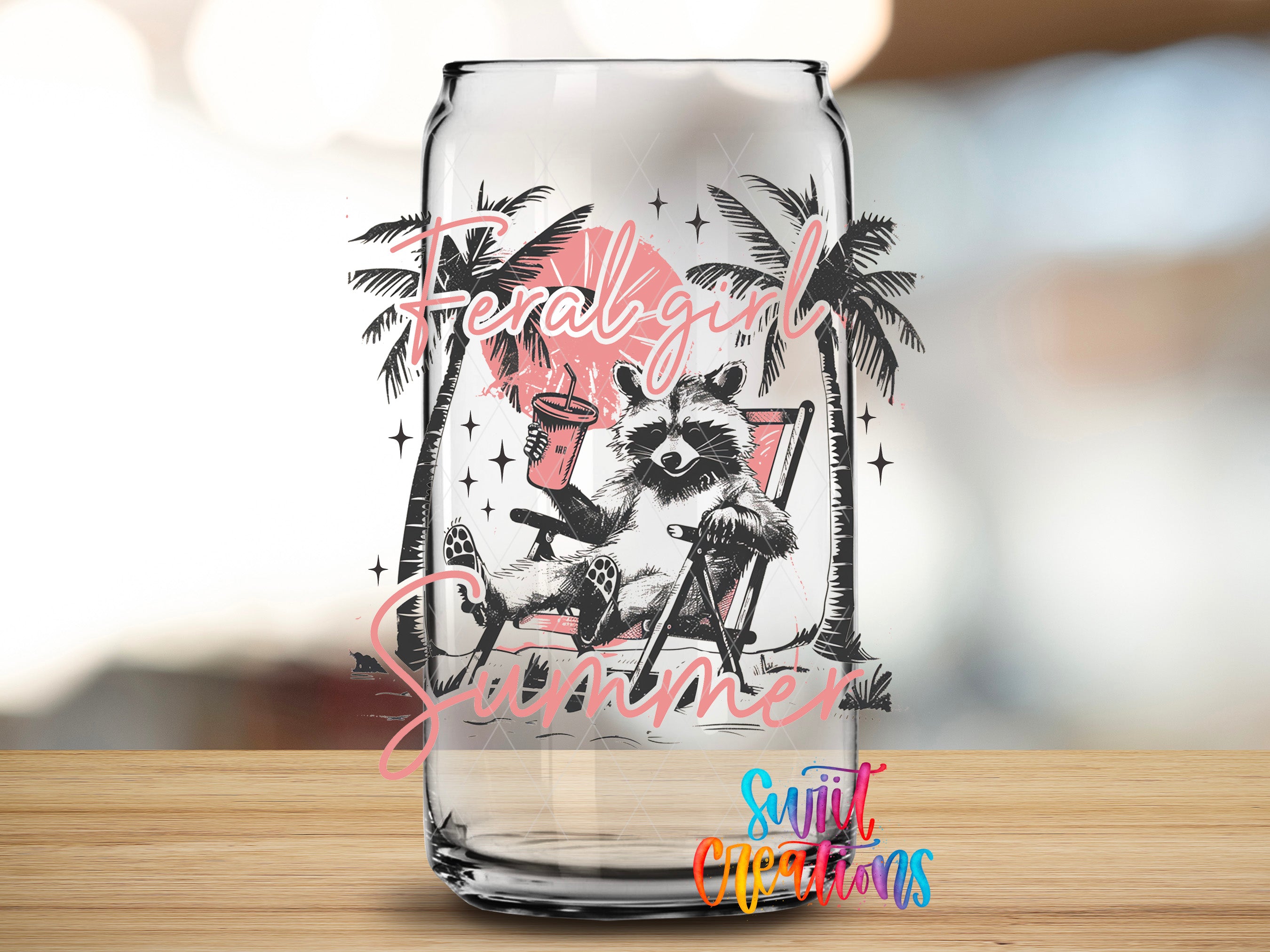 A glass can with a design featuring a raccoon sitting in a chair, surrounded by palm trees and the text "Feral Girl Summer".