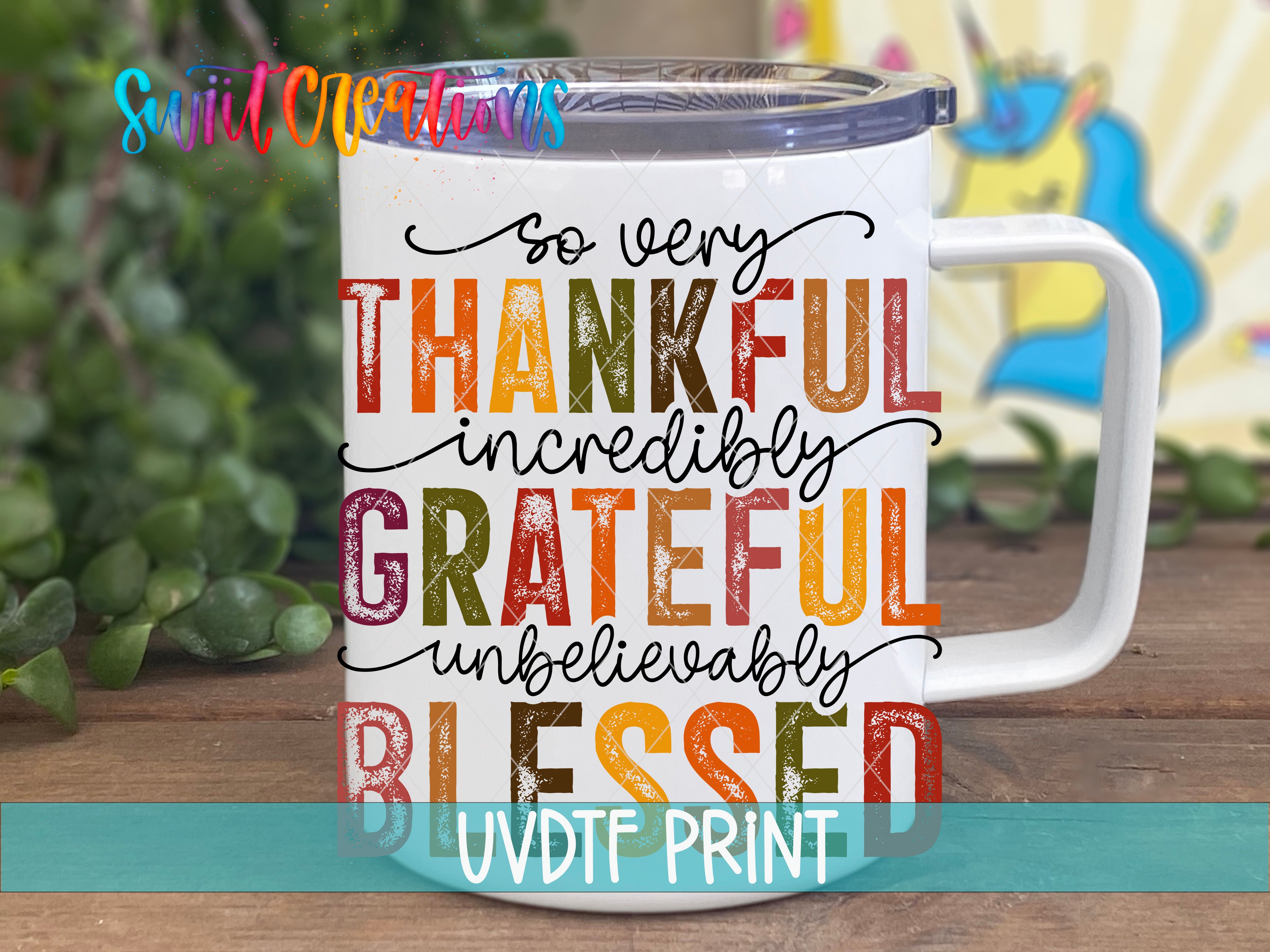 A white mug with a colorful text design that says "So very Thankful incredibly GRATEFUL definitely UNBELIEVABLY BLEEDED" printed on it.