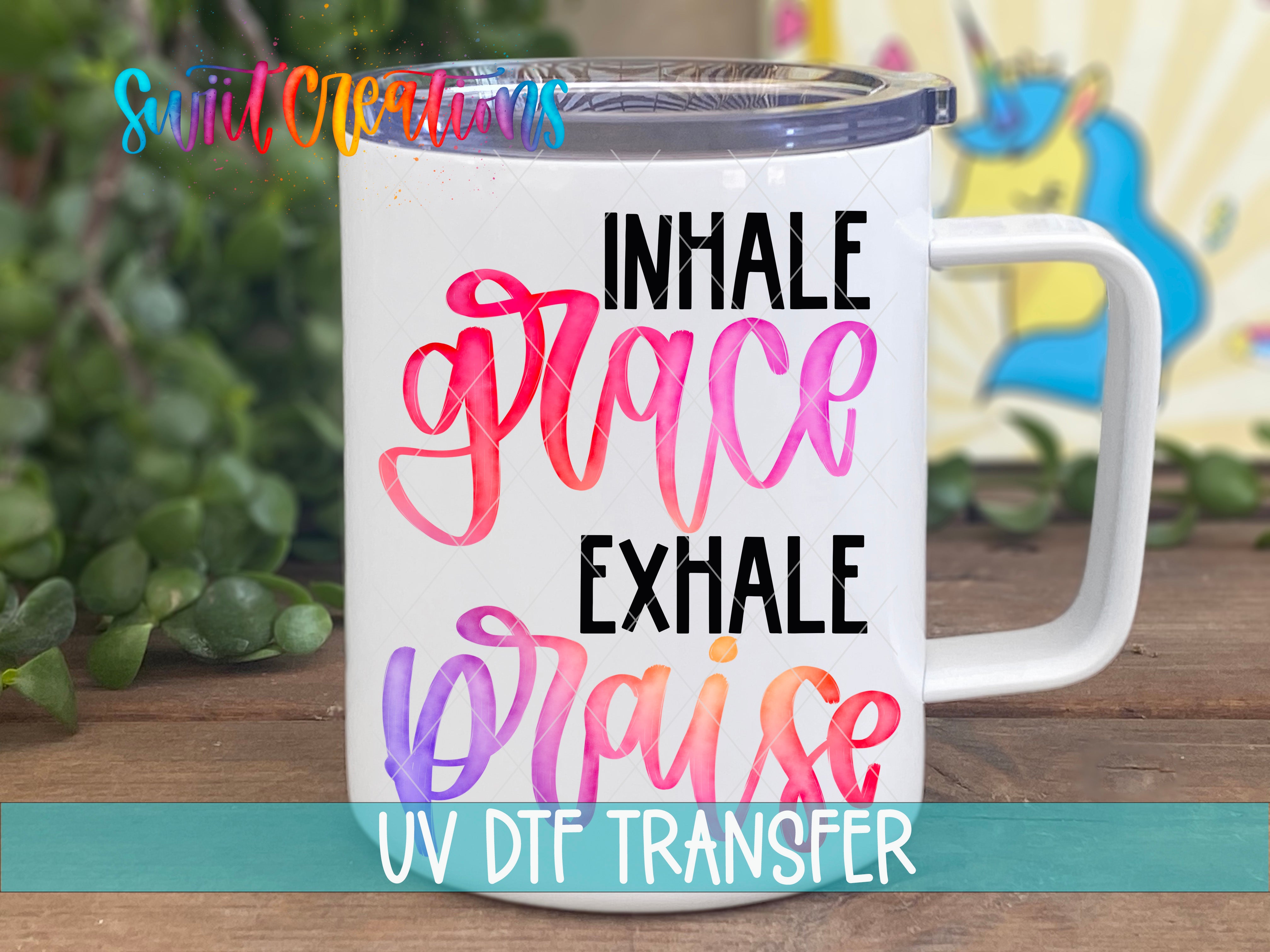 A white mug with colorful text that says "INHALE GRACE EXHAISE PRAISE" printed on it.