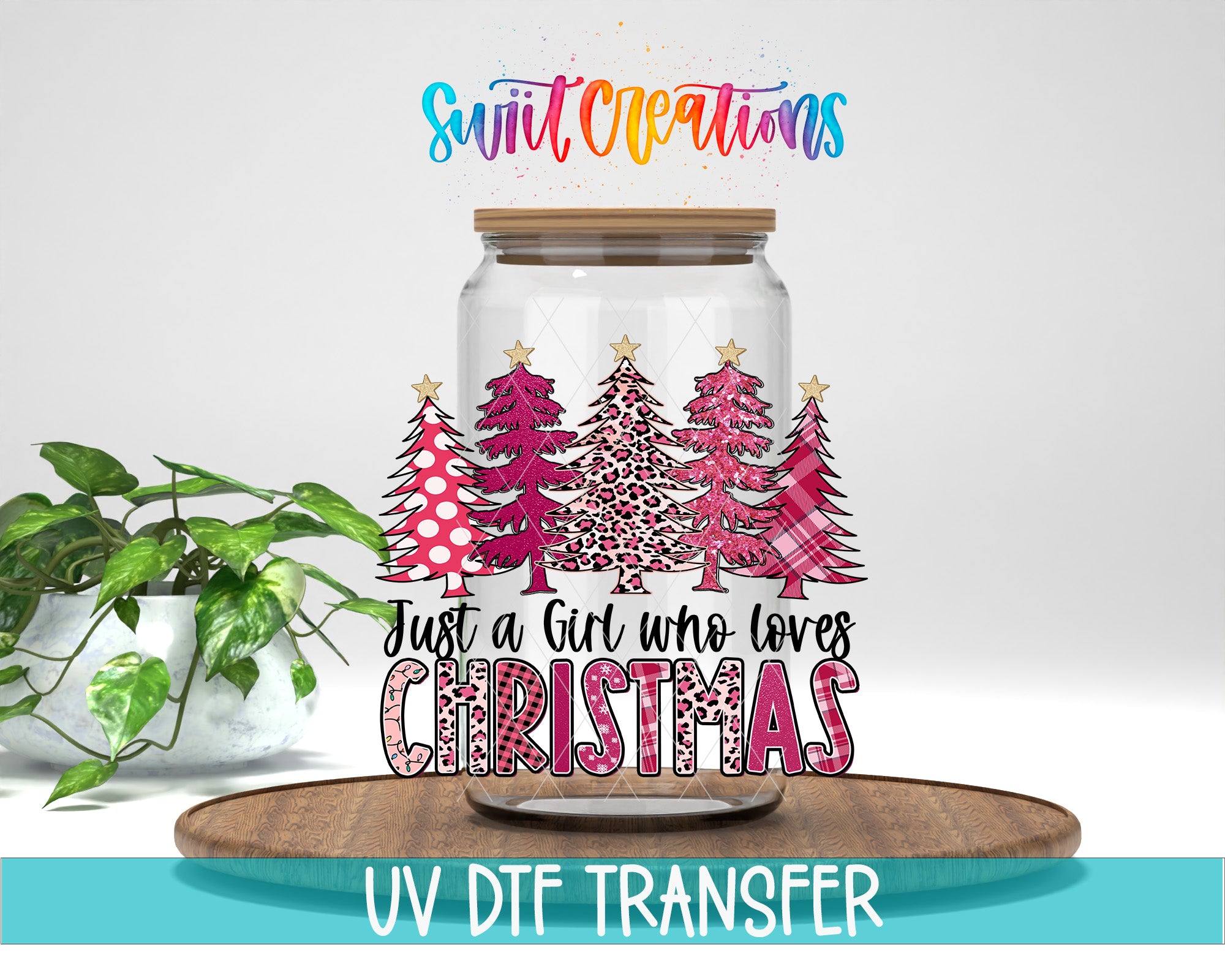 A glass jar with a Christmas tree design and text, placed on a wooden surface.