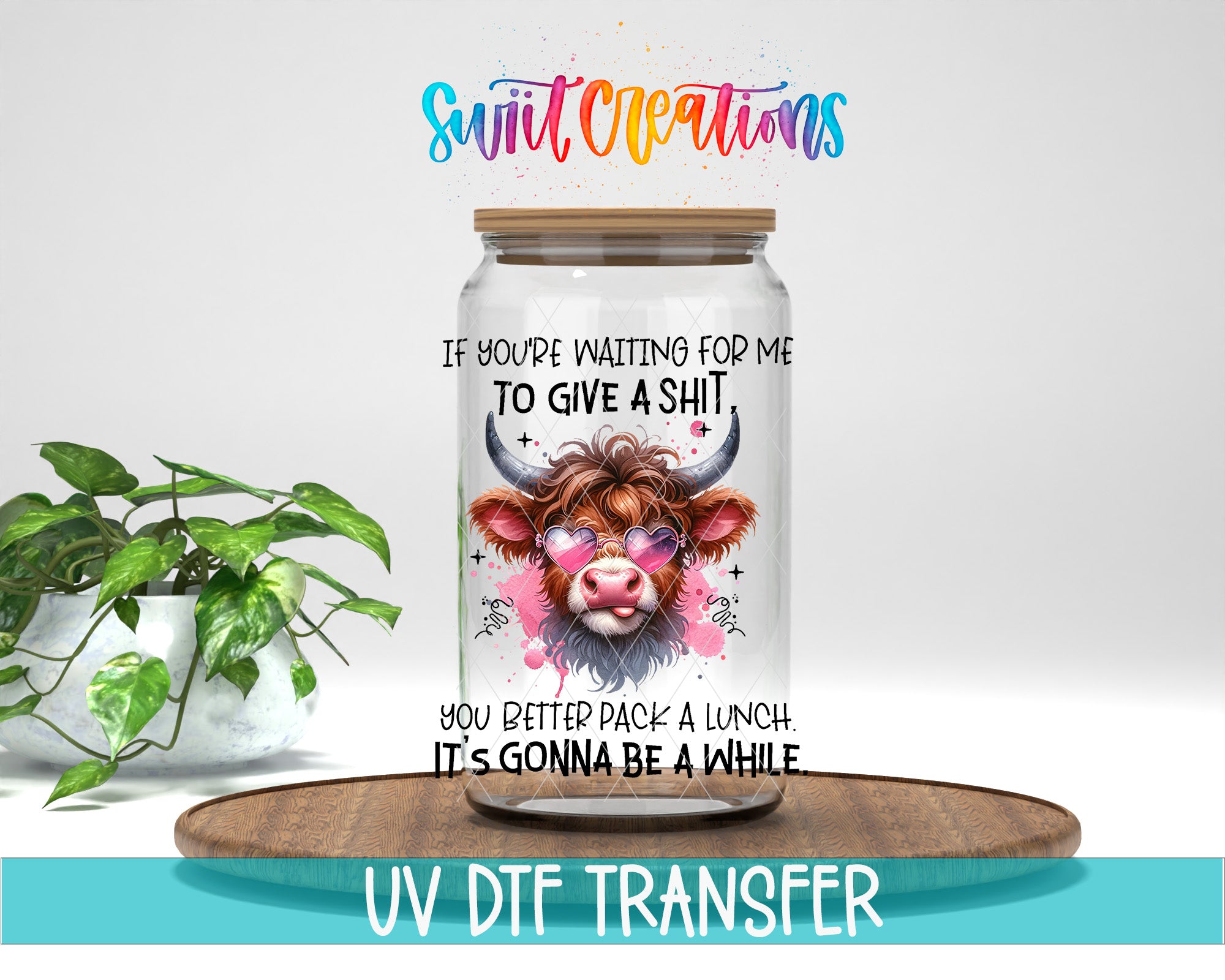 a glass jar with a cow's face and horns, along with text that reads "If you're waiting for me to give a shit, you better pack a lunch. It's gonna be a while." The jar is placed on a wooden tray, and there is a potted plant in the background.