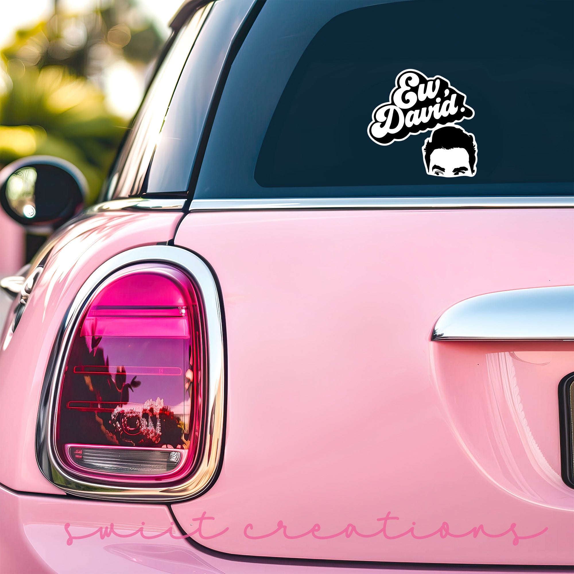 a pink car with a sticker on the back of it
