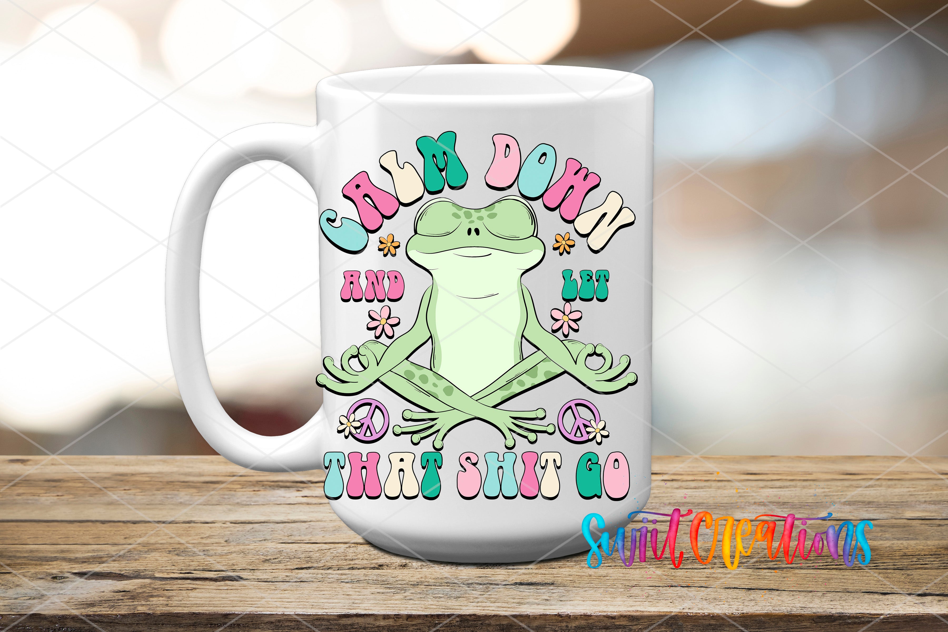 A white ceramic mug with a colorful design featuring a frog and the text "Chm down and let that shit go".