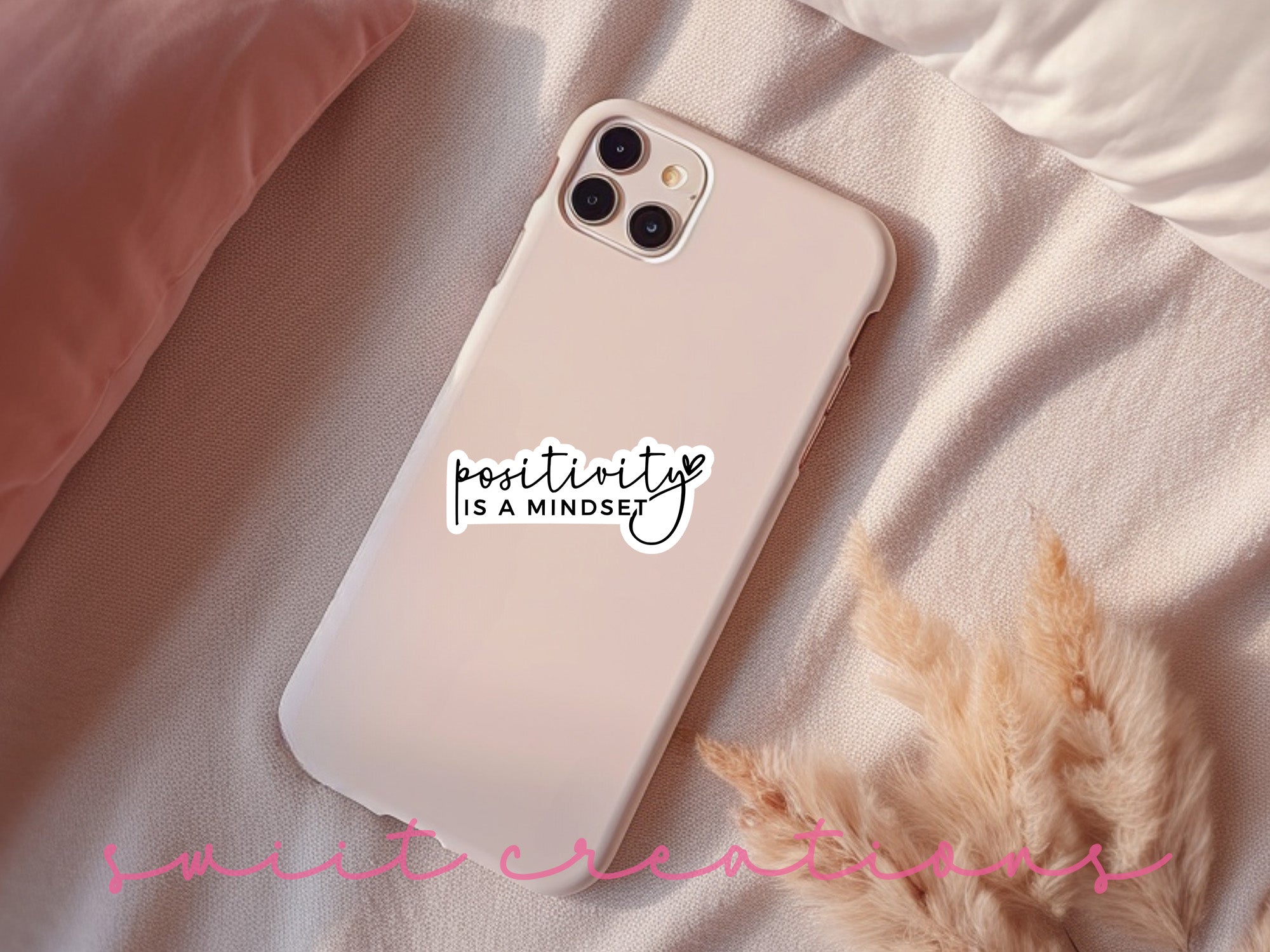a phone case with a sticker on it sitting on a bed