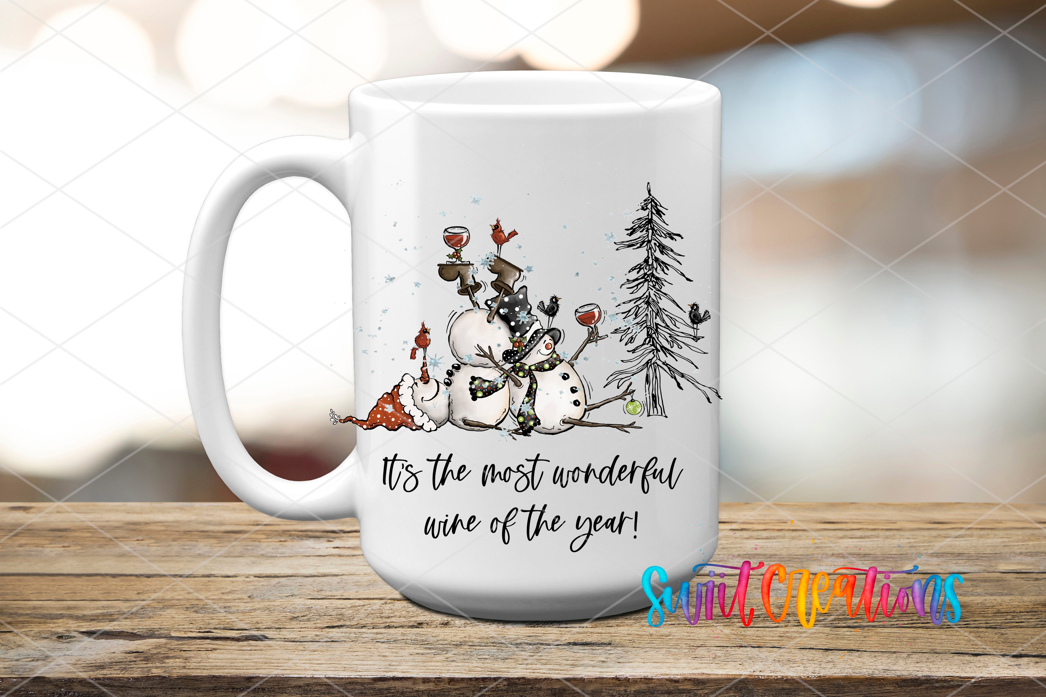 A white ceramic mug with a winter scene design featuring a snowman, a pine tree, and a bird. The mug has a text that reads "It's the most wonderful wine of the year!"