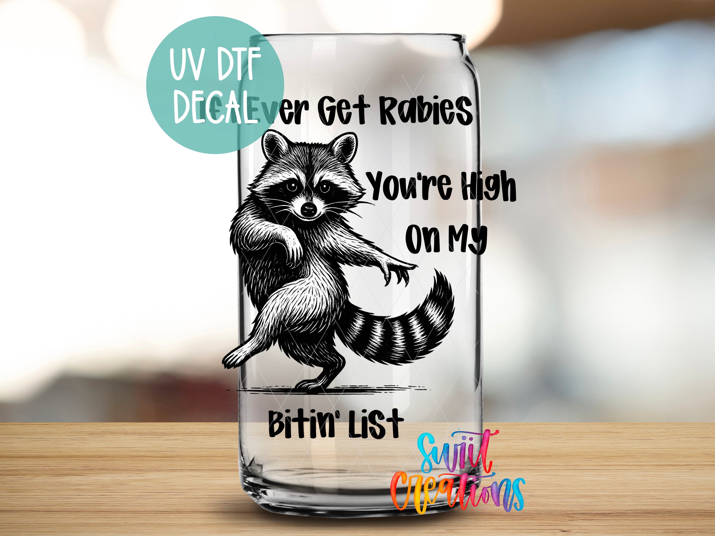 A glass can with a raccoon illustration and text on it, placed on a wooden surface.
