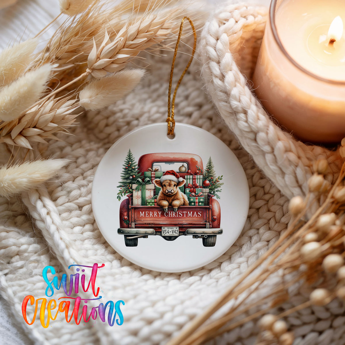 A white ceramic ornament featuring a red vintage truck with a dog in the back, surrounded by Christmas decorations and a lit candle.