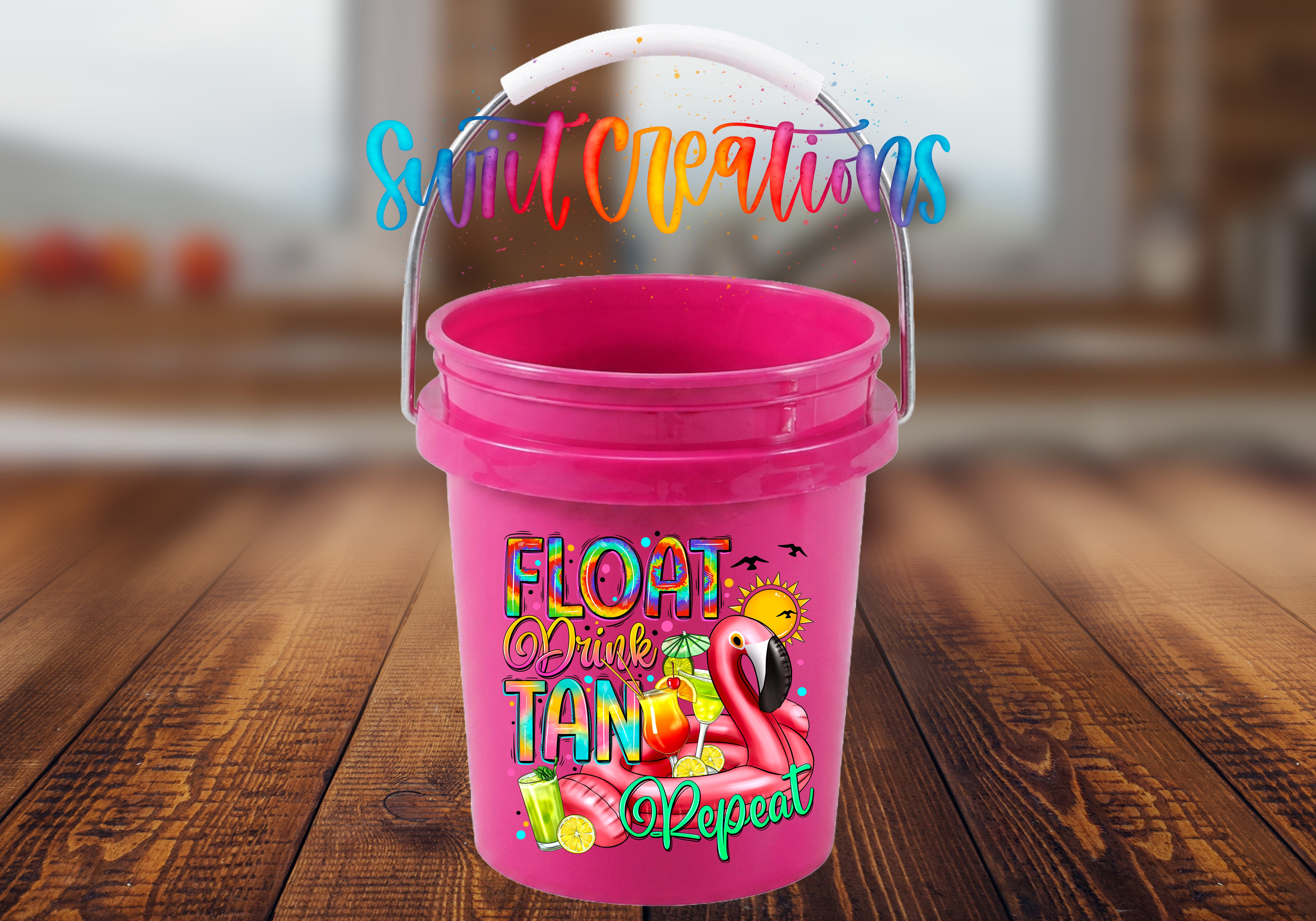 A pink bucket with a colorful design featuring a flamingo and the text "FLOAT DRINK TAN" printed on it.