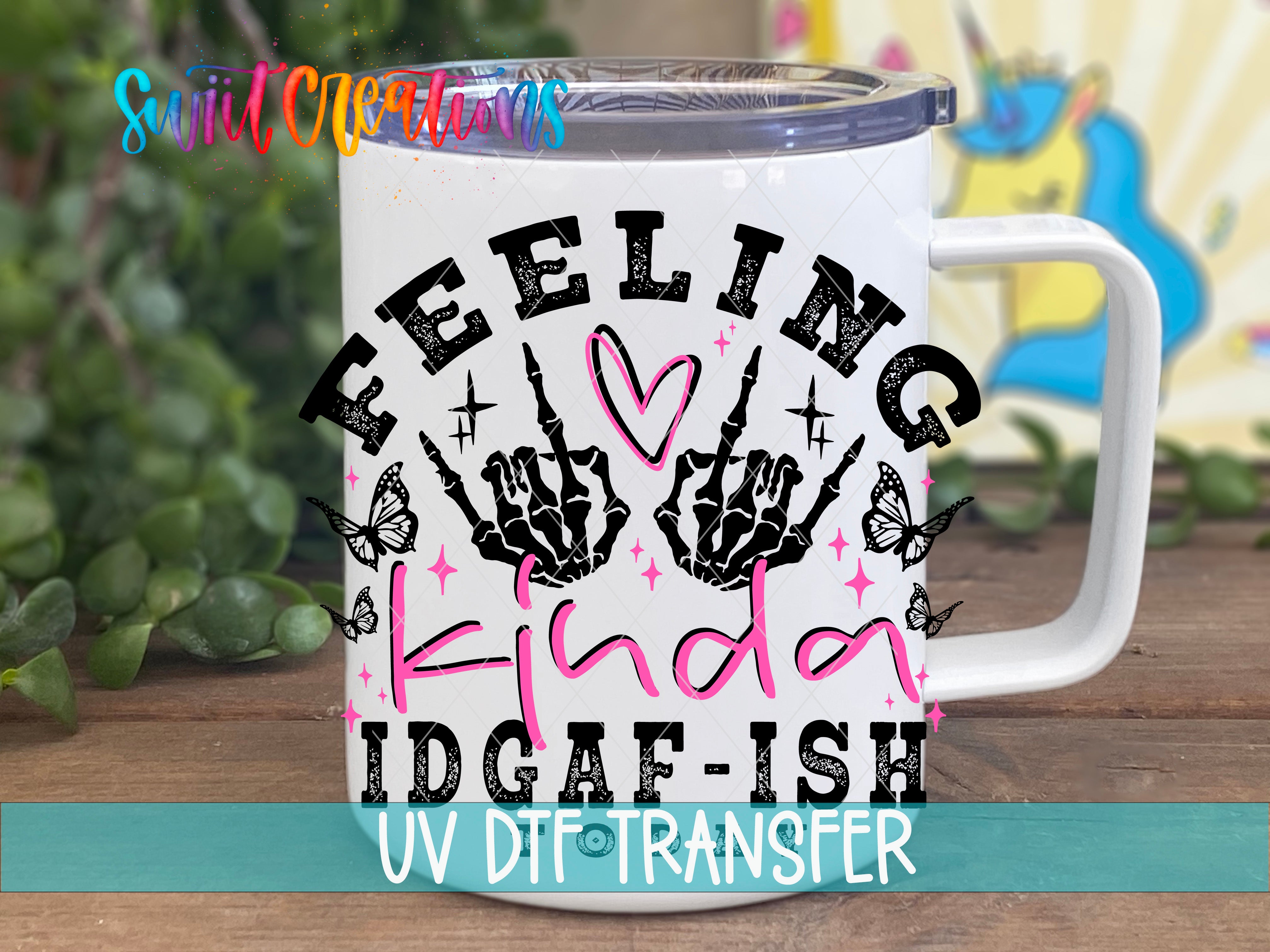 A white mug with a colorful graphic design featuring the text "Feeling kind of idgafish" and a skeleton hand holding a heart.