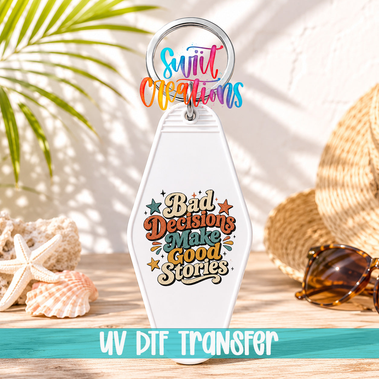 A keychain with a colorful design and text, placed on a wooden surface with sunglasses and a straw hat in the background.