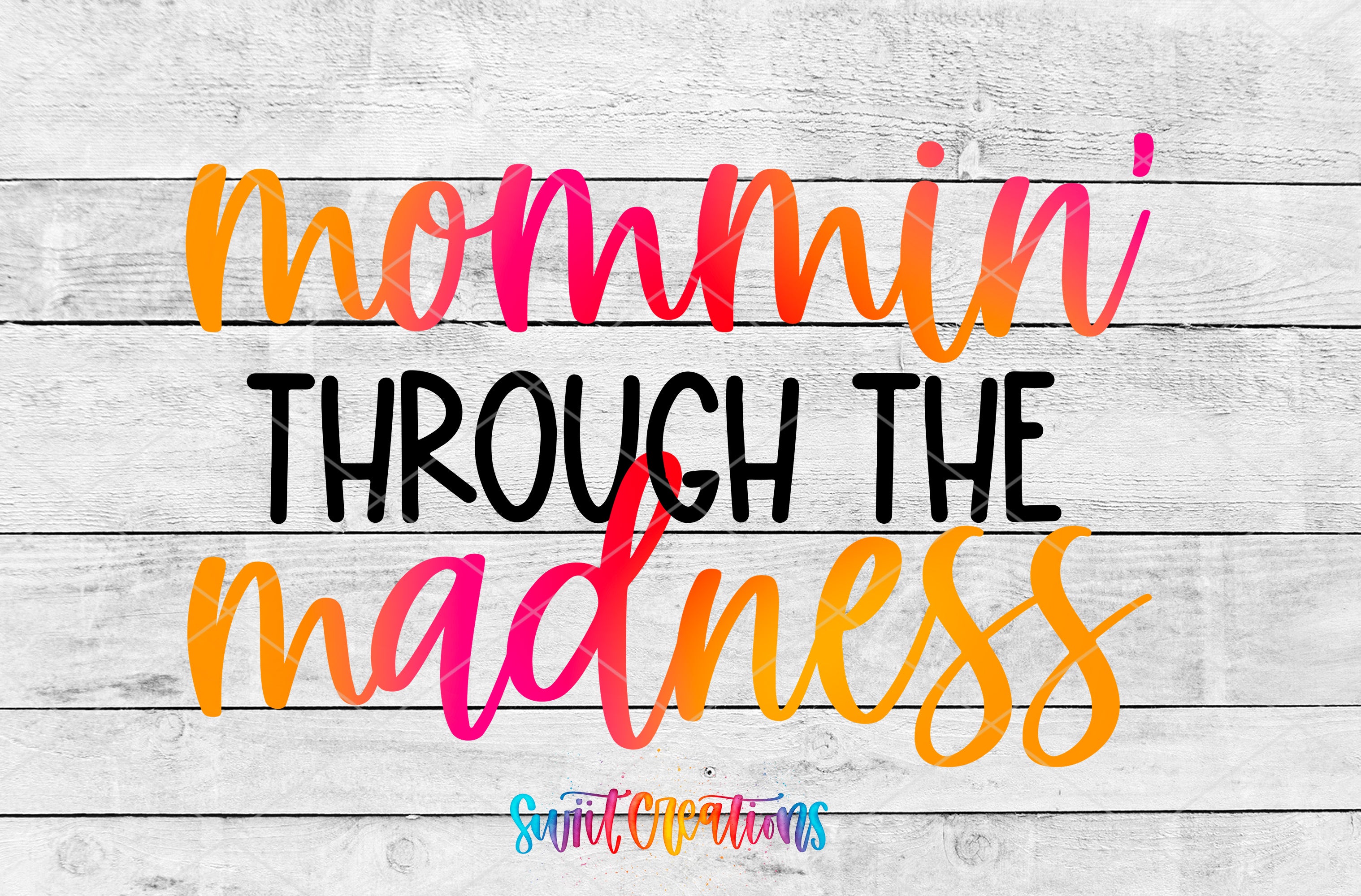 the text "momma through the madness" in a colorful, cursive font against a white wooden background.