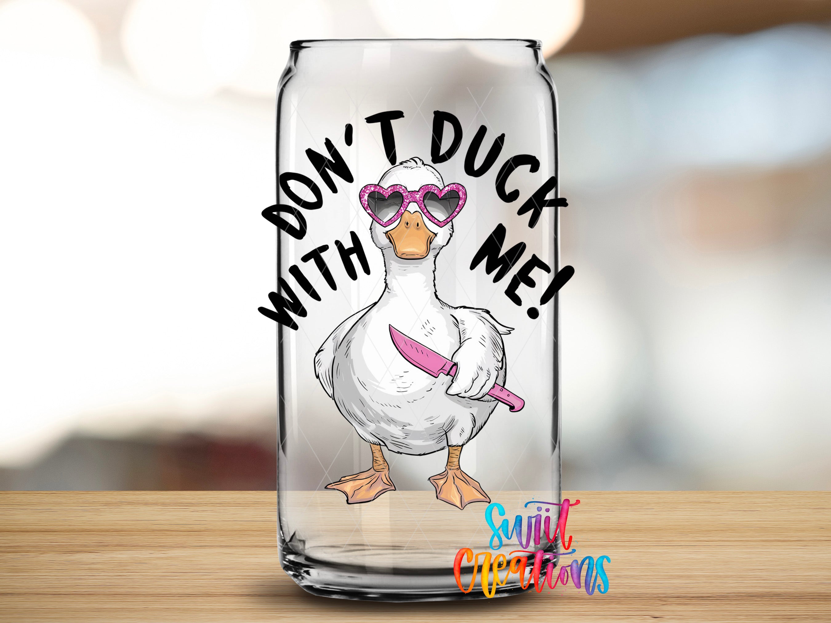 A glass can with a cartoon duck wearing sunglasses and holding a knife, with the text "DON'T DUCK ME!" written above it.