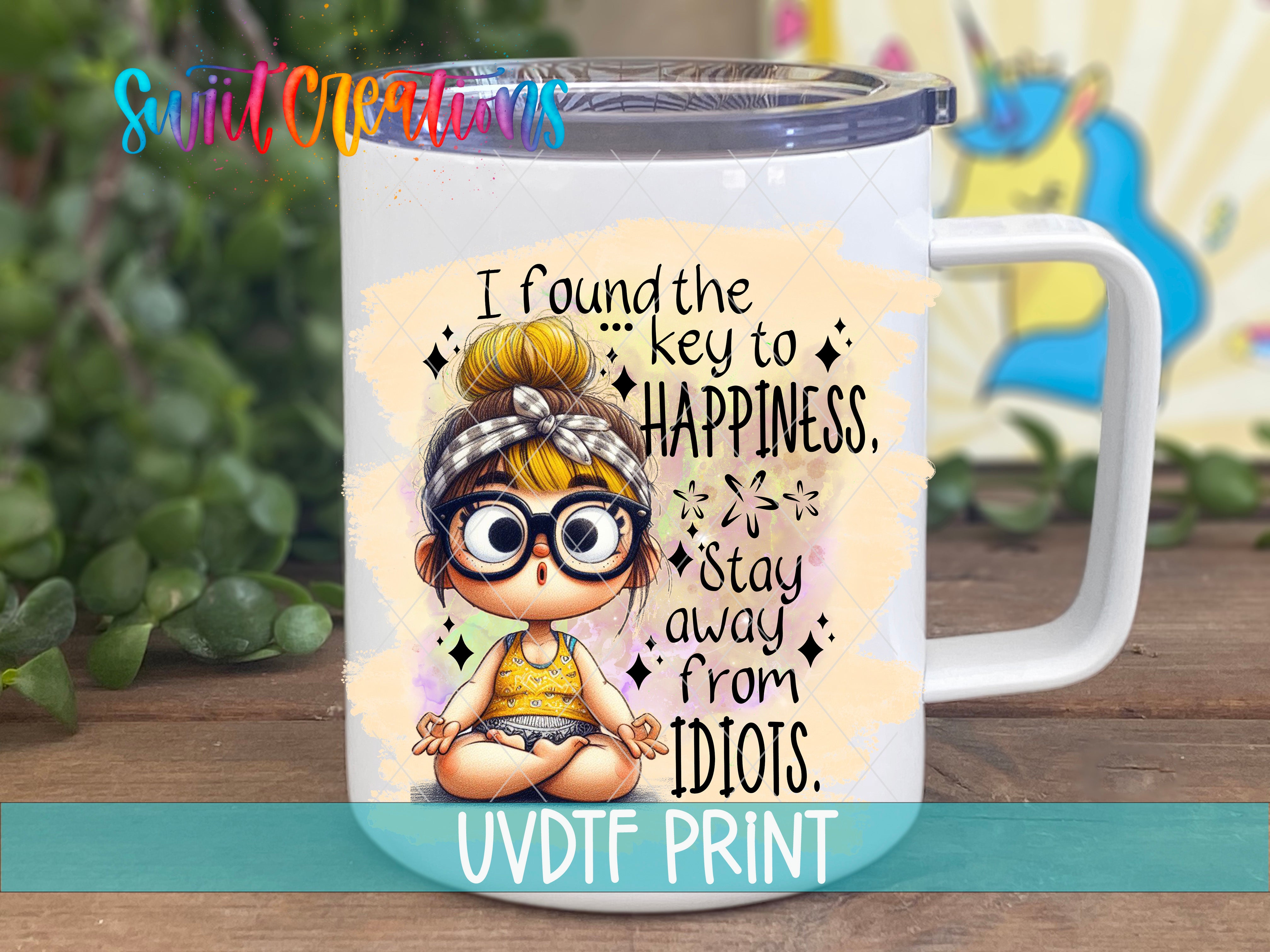 A white mug with a printed design featuring a cartoon girl with glasses and a bow in her hair, along with text that says "I found the key to happiness. Stay away from Idiots."