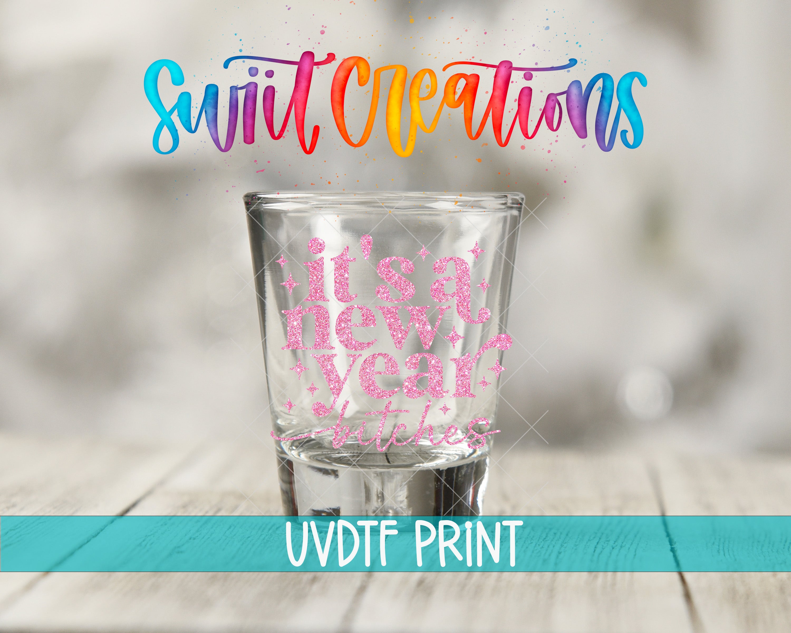a shot glass with a colorful, glittery design and text that reads "It's a new year and new year starts" in a rainbow color scheme.