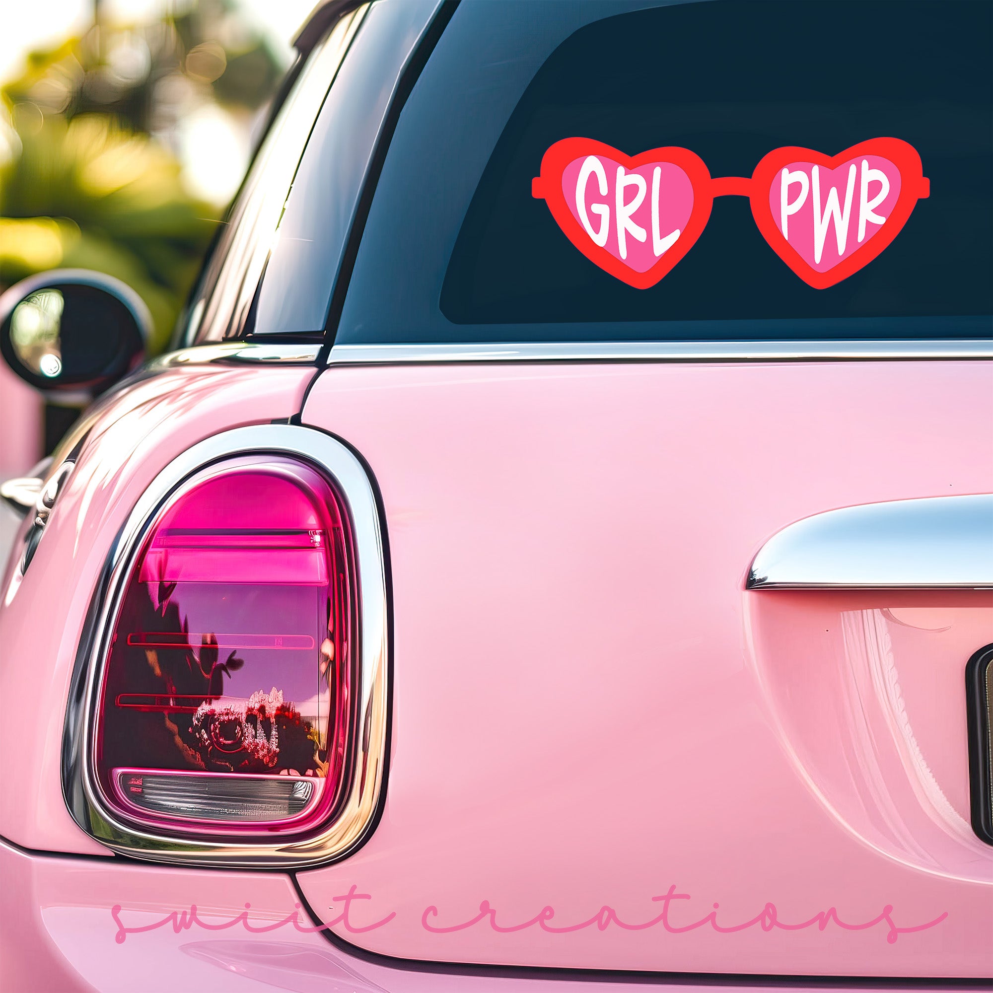 a pink car with two heart shaped stickers on it