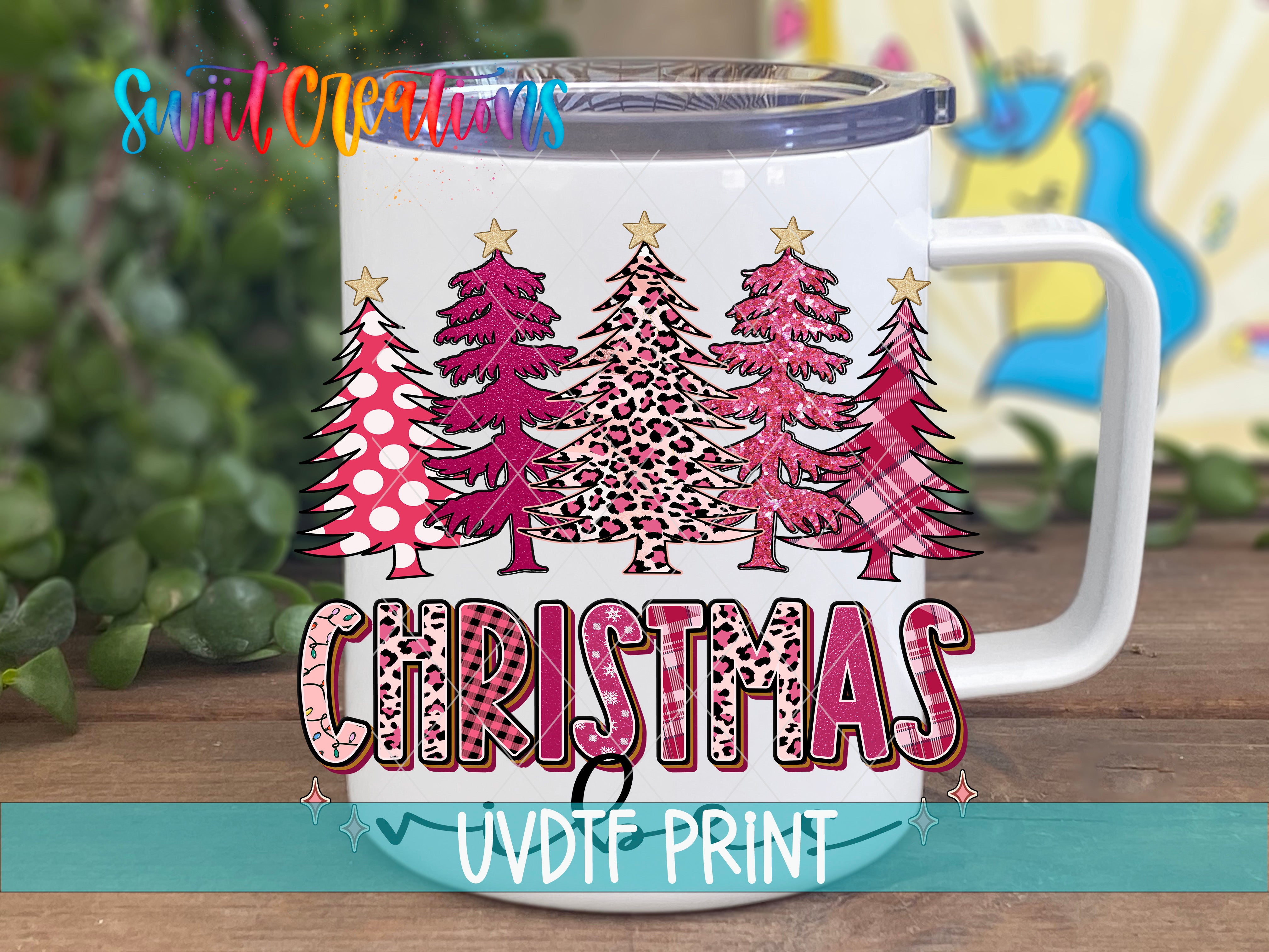 A white mug with a Christmas tree design printed on it, placed on a wooden surface.