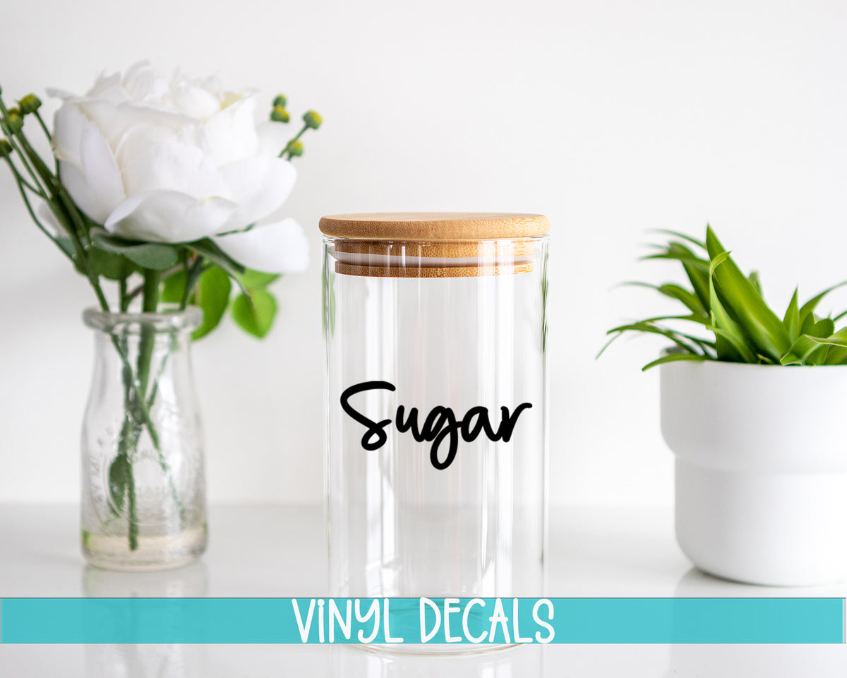a glass jar with a wooden lid sitting next to a vase with flowers