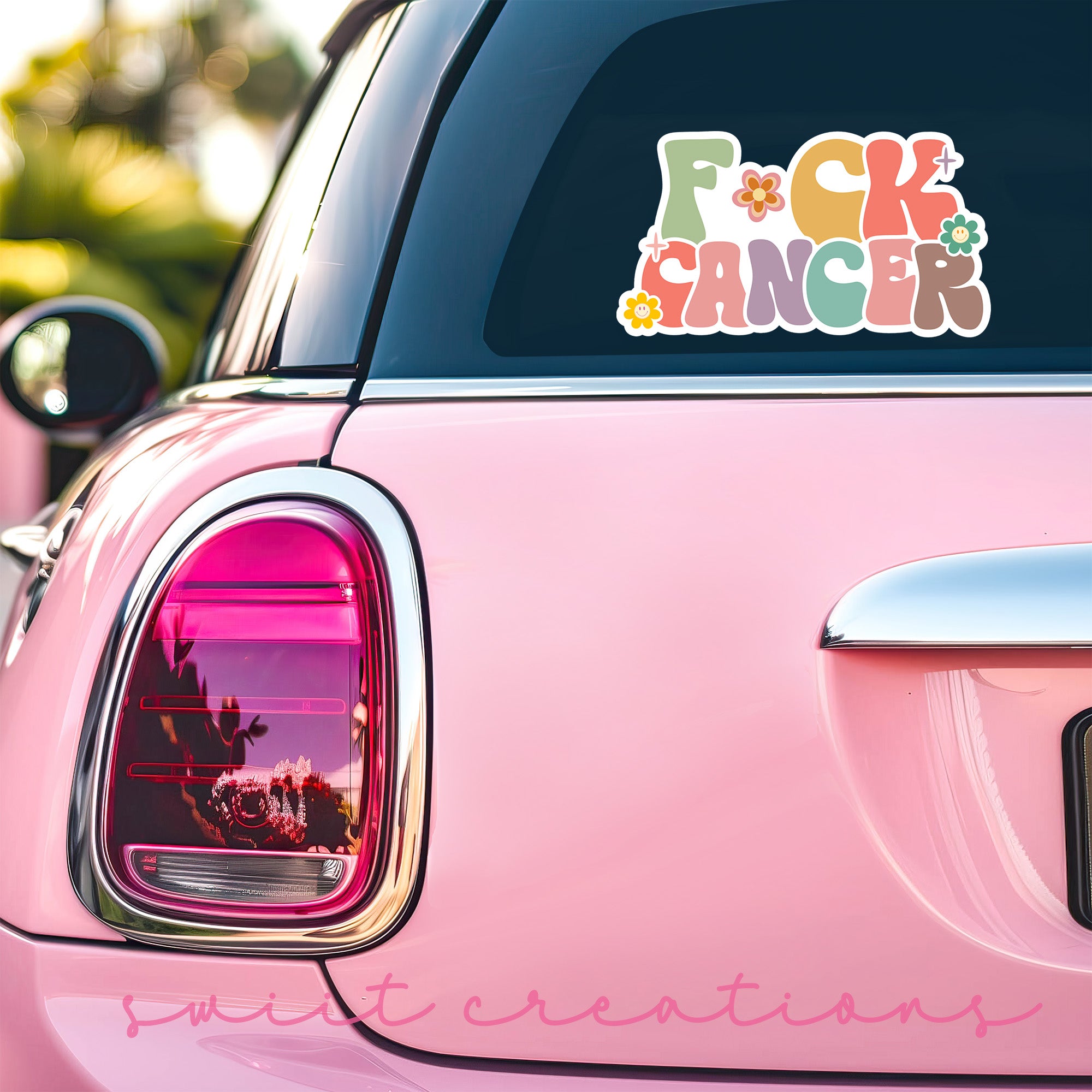 a pink car with a sticker on the back of it