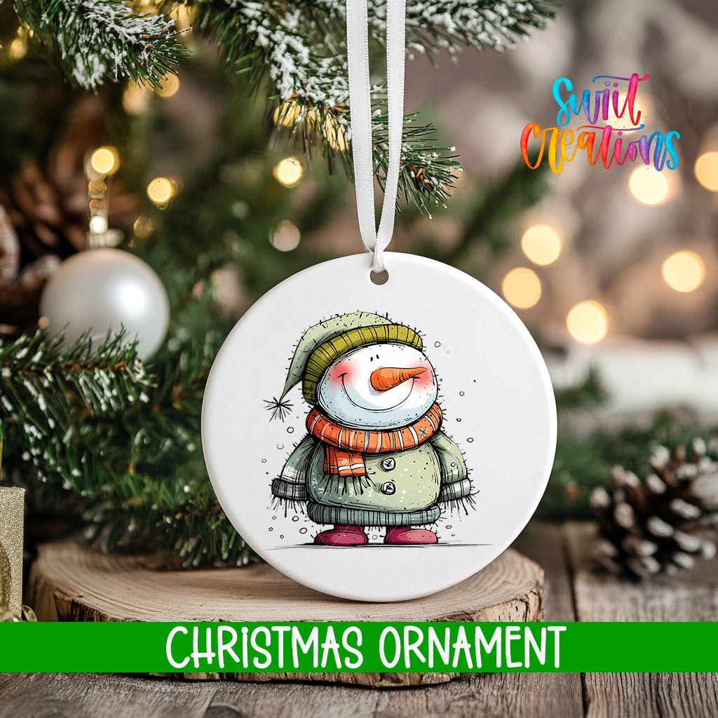 A white Christmas ornament featuring a snowman is hanging from a tree branch, with a blurred background of pine branches and twinkling lights.