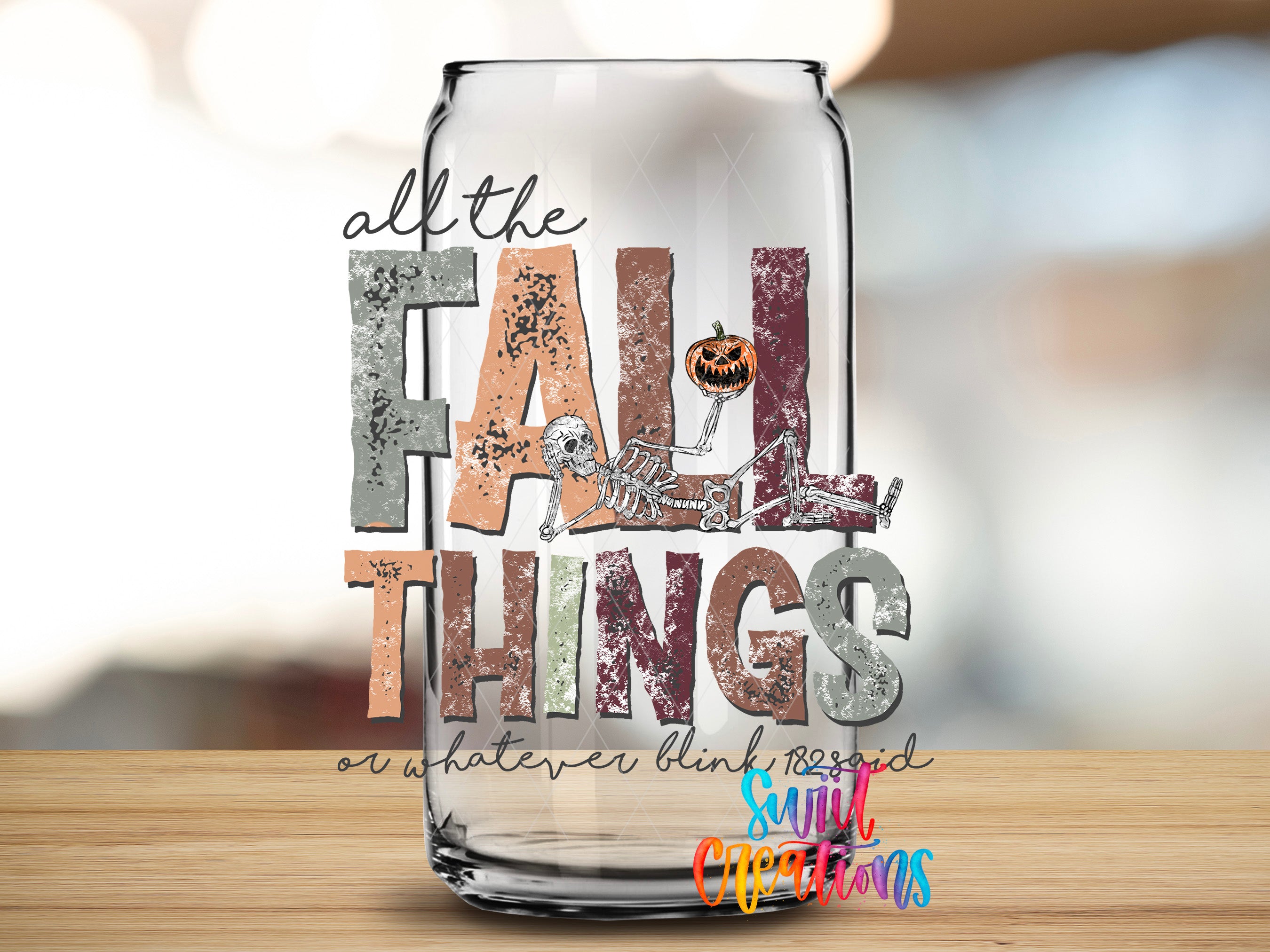 a glass can with the text "all the FALL THINGS or whatever" and a skeleton figure, along with a pumpkin decoration.
