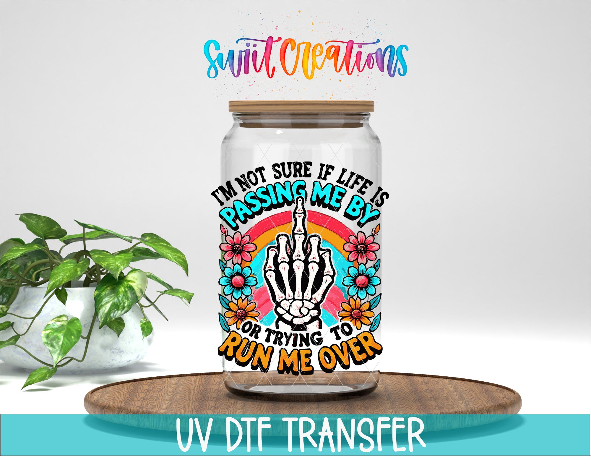 a glass jar with a colorful and artistic design, including a skeleton hand, flowers, and a rainbow. The text on the jar reads "I'm not sure if life is passing me by, or trying to run me over".