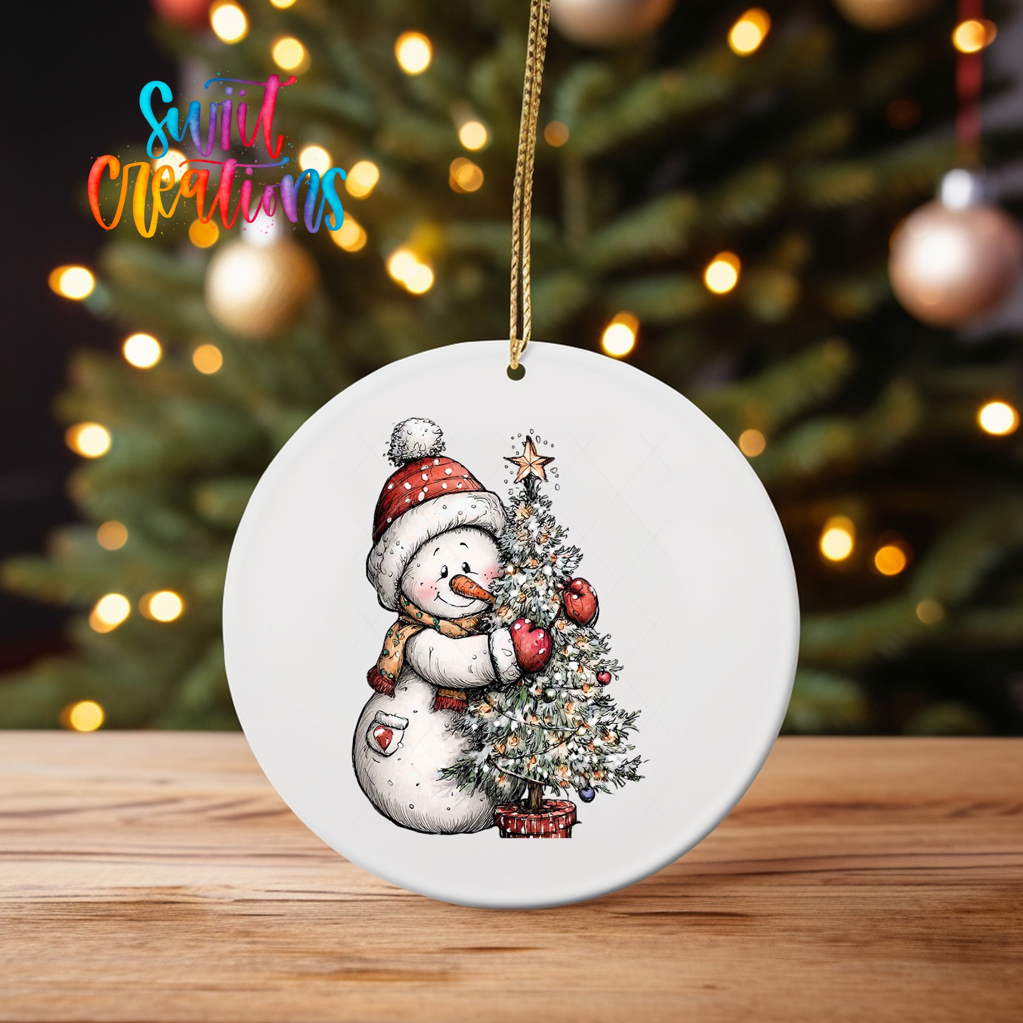 A white ceramic ornament featuring a snowman holding a Christmas tree, with a blurred background of a decorated Christmas tree.